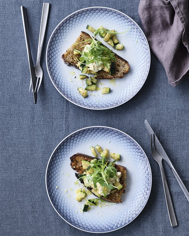 Linnen tafelkleed van Himla, linnen servet van Broste Copenhagen, bestek met een stonewashed finish van Table Noir en lunchborden uit de collectie HAV van Royal Copenhagen. Twee borden zuurdesem toast met burrata