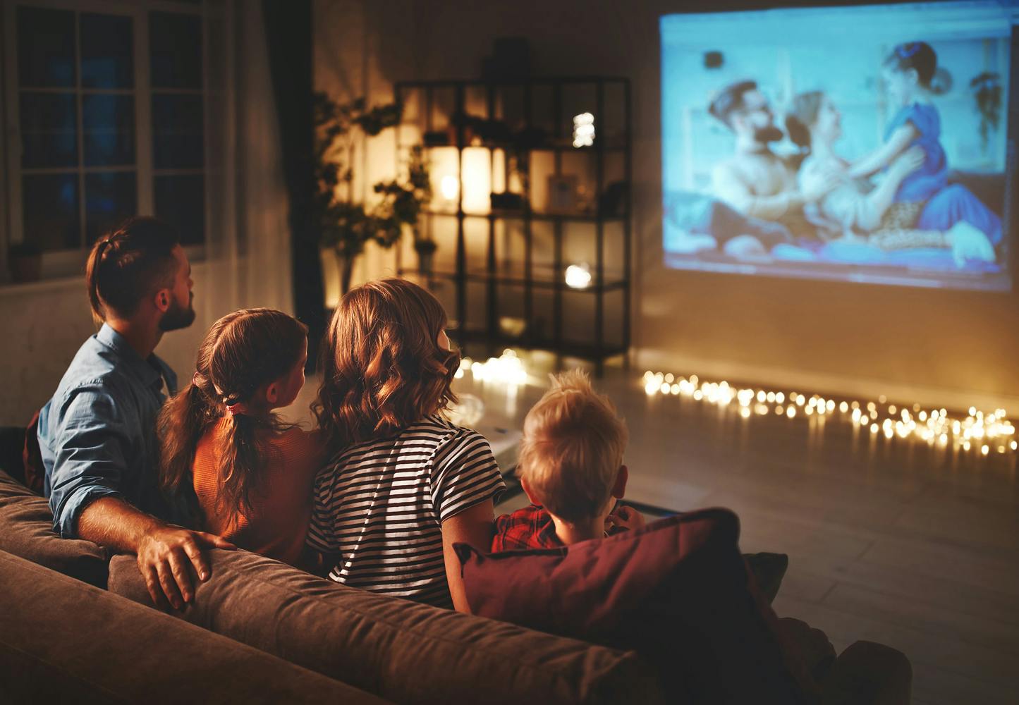 Familie ser på lysbildefremvisning på TV