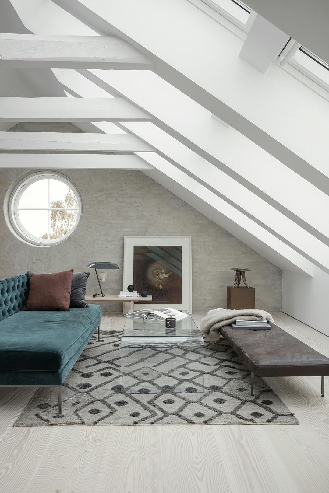 Het interieur is minimalistisch, maar meubels in verschillende materialen en kleuren voegen visueel leven toe. Loft met minimalistisch interieur en dakramen