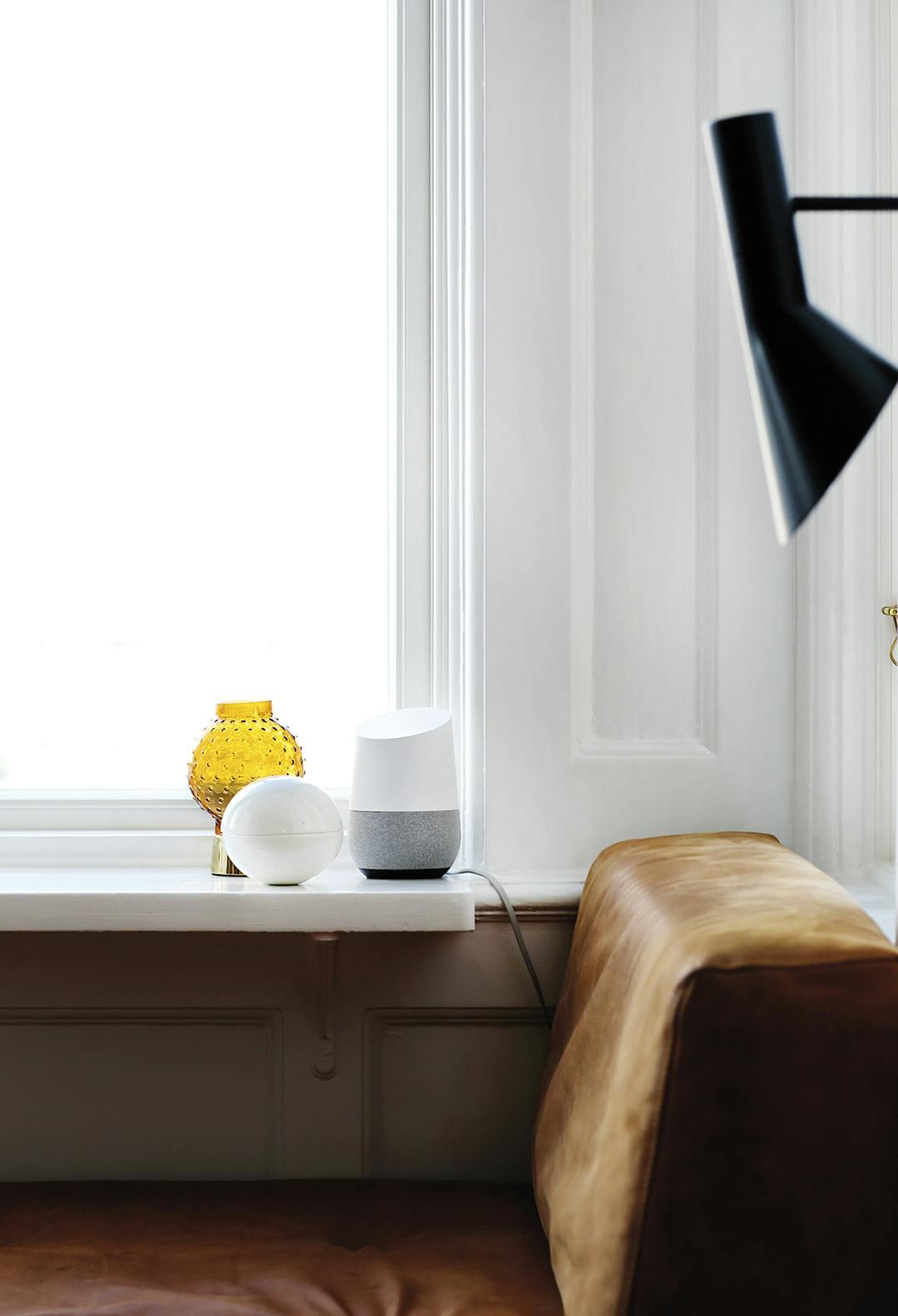 De favoriete plek, met uitzicht over de haven. Hier staat Google Home klaar met muziek, licht, weerberichten enz. Google Home op vensterbank, met vintage leren bank.