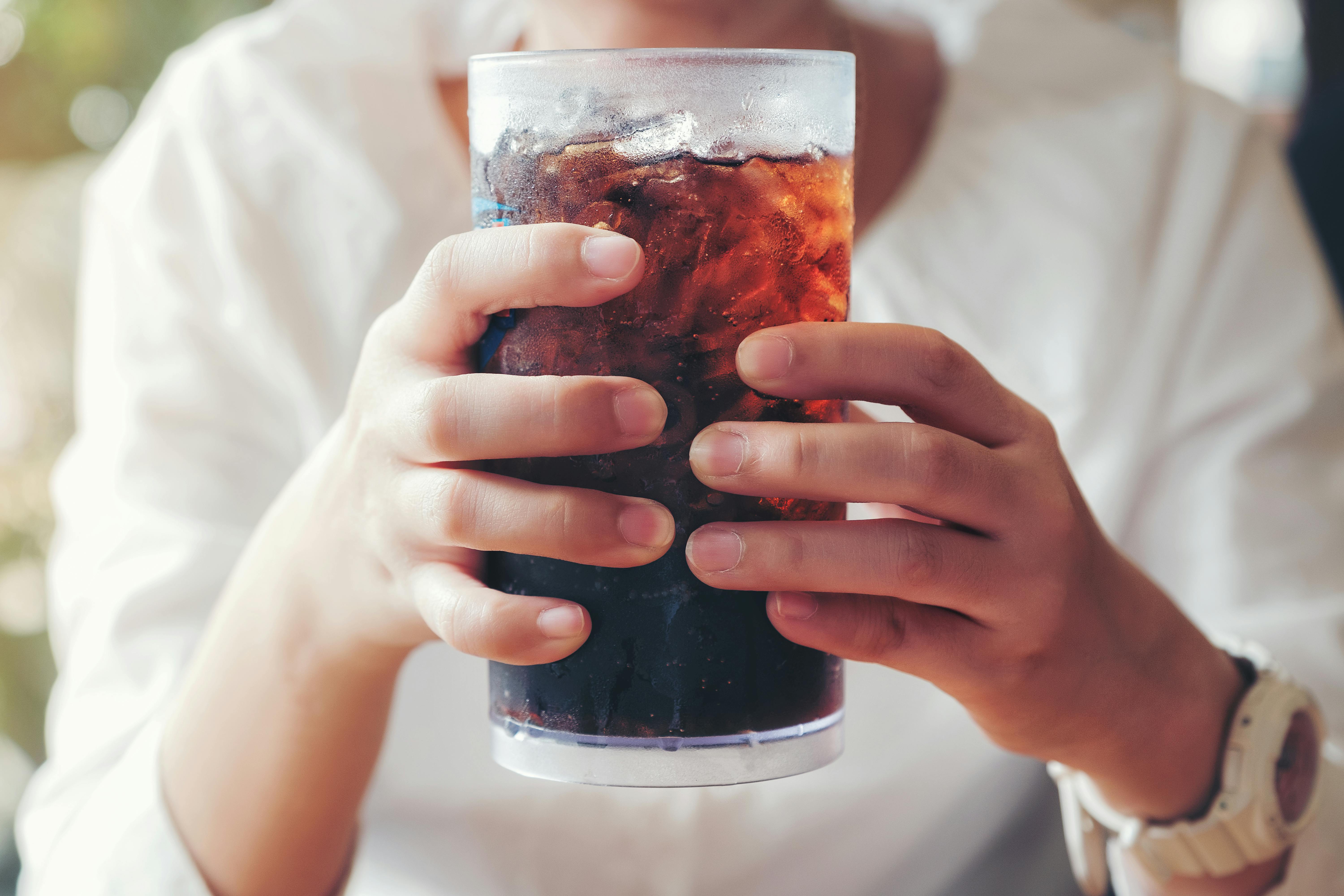 Sara elsker alt ved cola. Hænder med cola