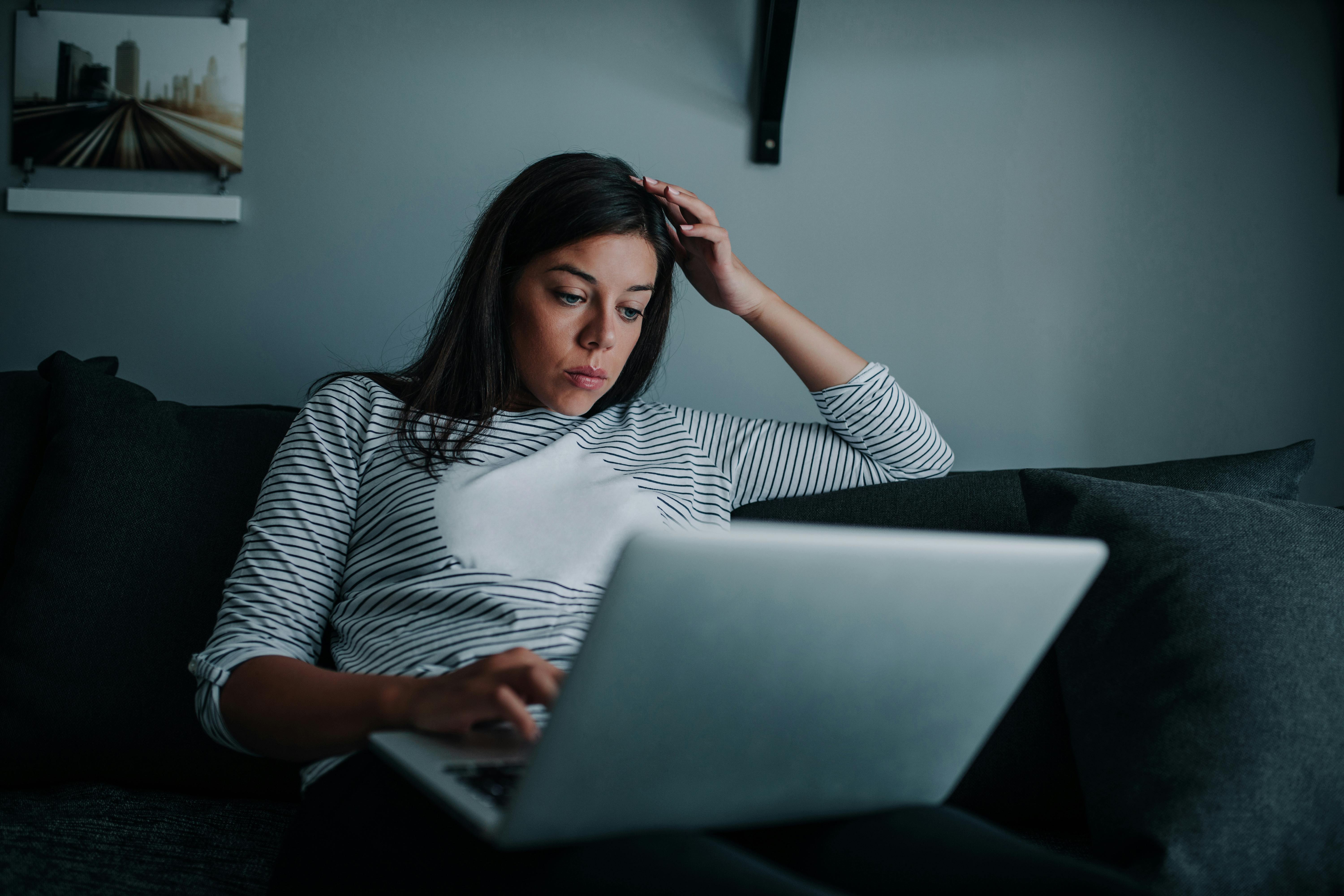 En person med social angst har tendens til at isolere sig fra andre mennesker. En kvinde isolerer sig selv derhjemme med sin computer