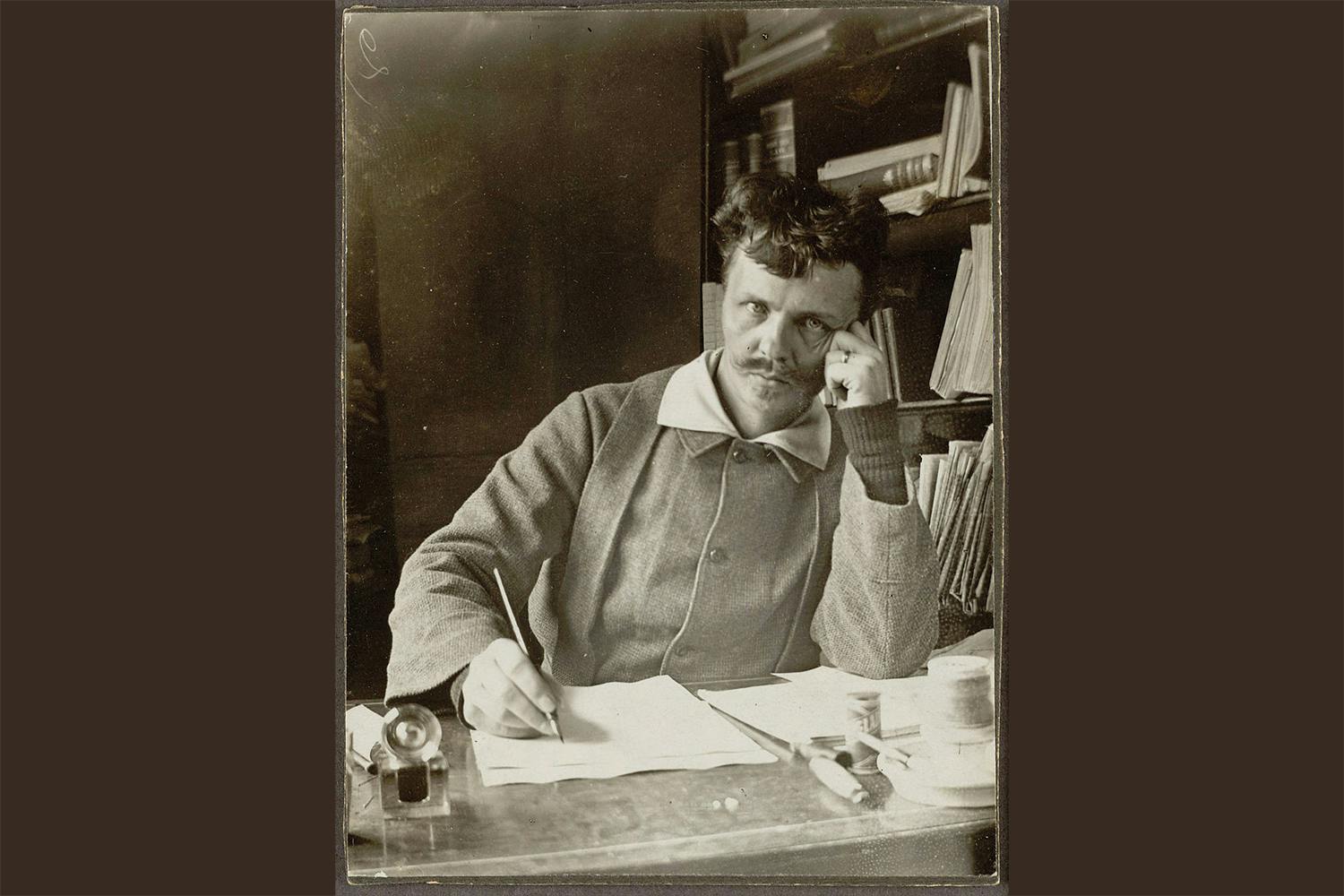 Fotografiskt självporträtt av August Strindberg, taget vid skrivbordet 1886.