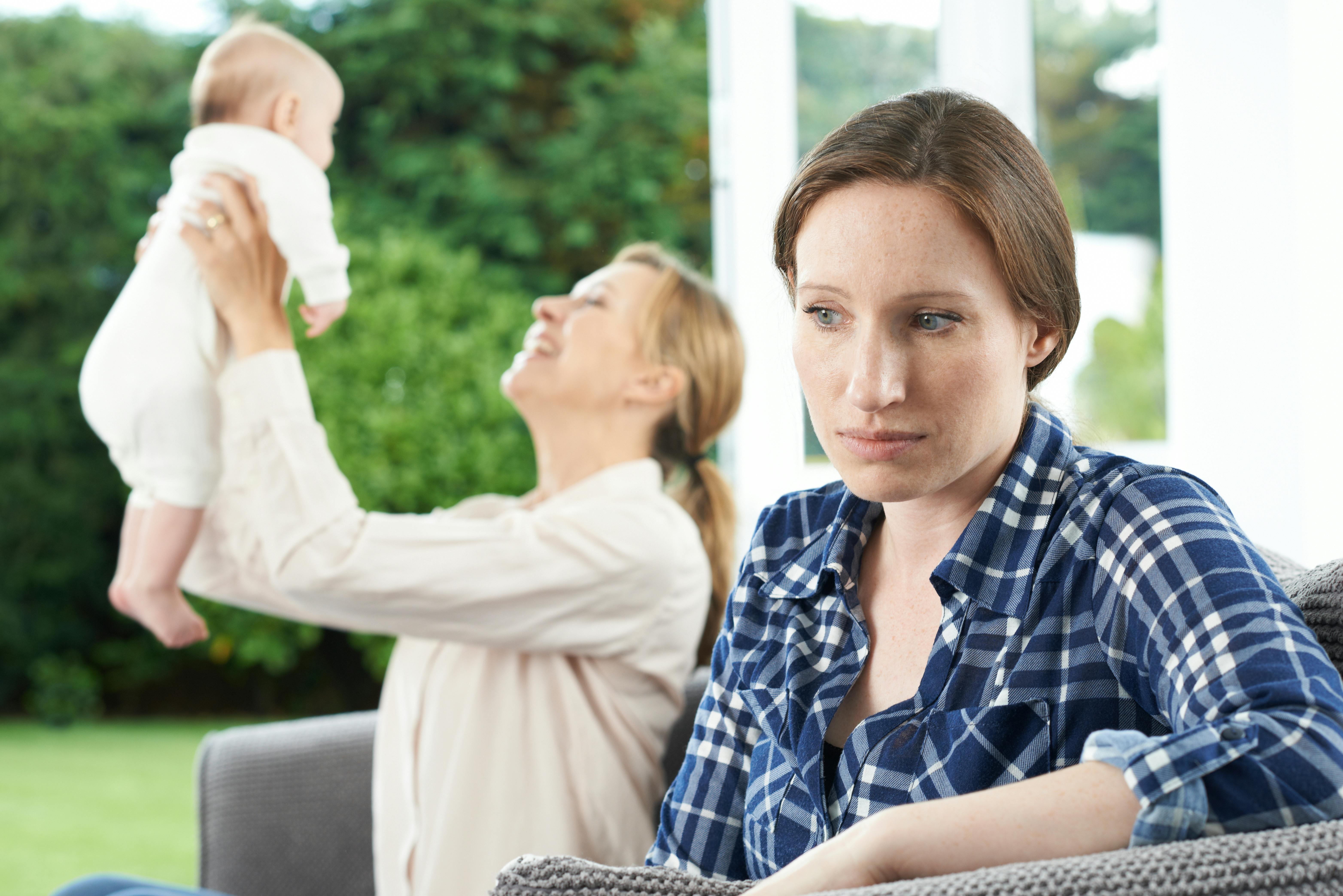 Det er helt normalt at have en følelse af, ikke at passe ind i “mor-klubben”. Kvinde misundelig på sin veninde med baby