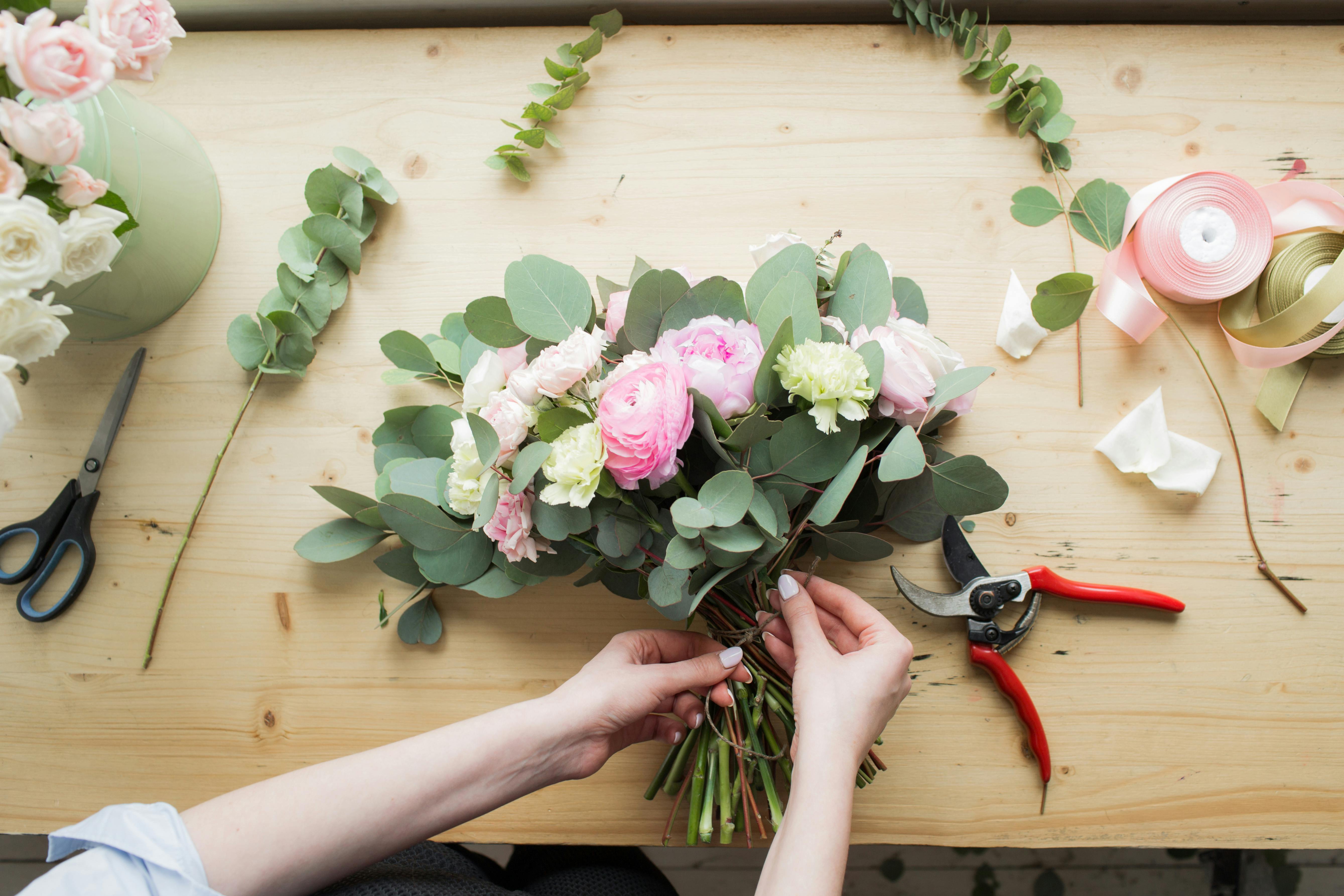 På et kursus i blomsterbinding lærer du at sammensætte de fineste buketter. Kvinde binder blomster