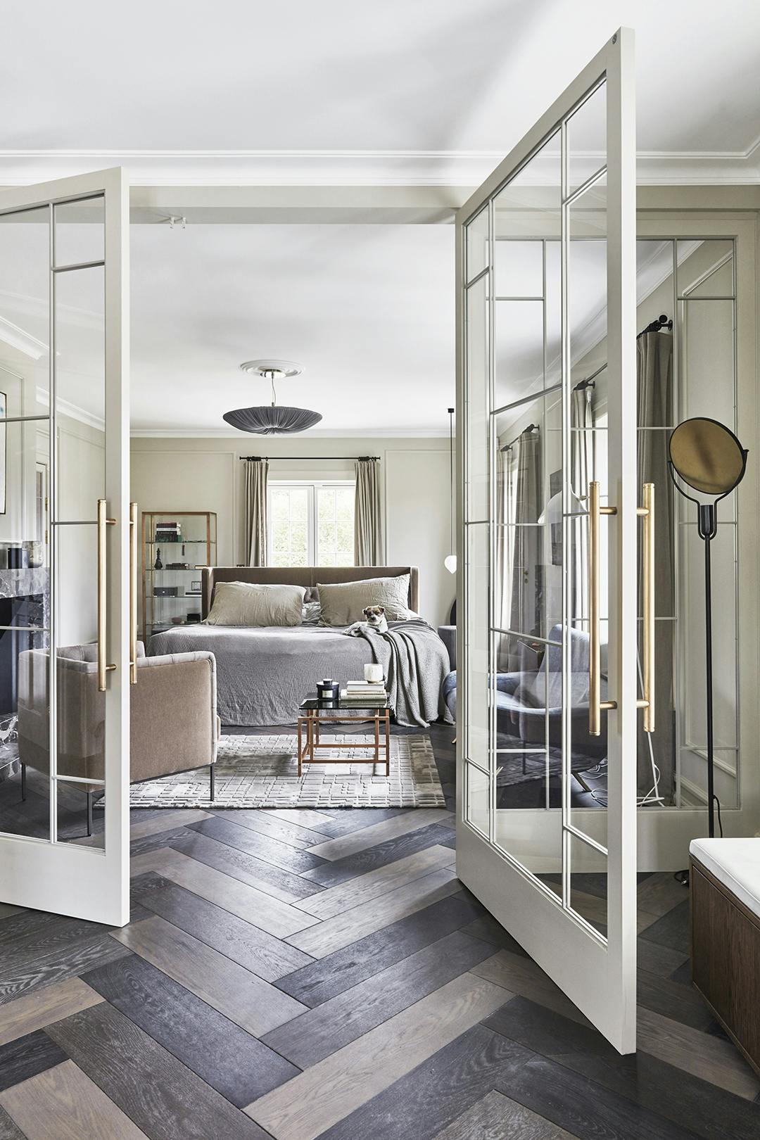 De slaapkamer biedt toegang tot een balkon, de kleedruimte en een badkamer, wat een groot gevoel van luxe en wellness geeft. Witte glazen binnendeuren en visgraat parket