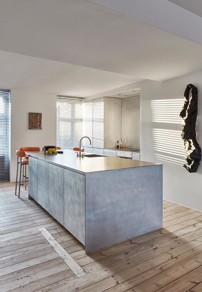 David ontwierp de keuken en werd in productie genomen door Reform Copenhagen. minimalistisch keukeneiland met onbewerkte houten vloer