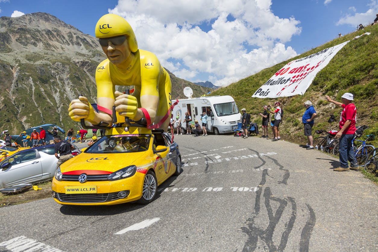 Den gula färgen är en symbol för Tour de France Figur med gul tröja ovanpå bilen i Tour de France