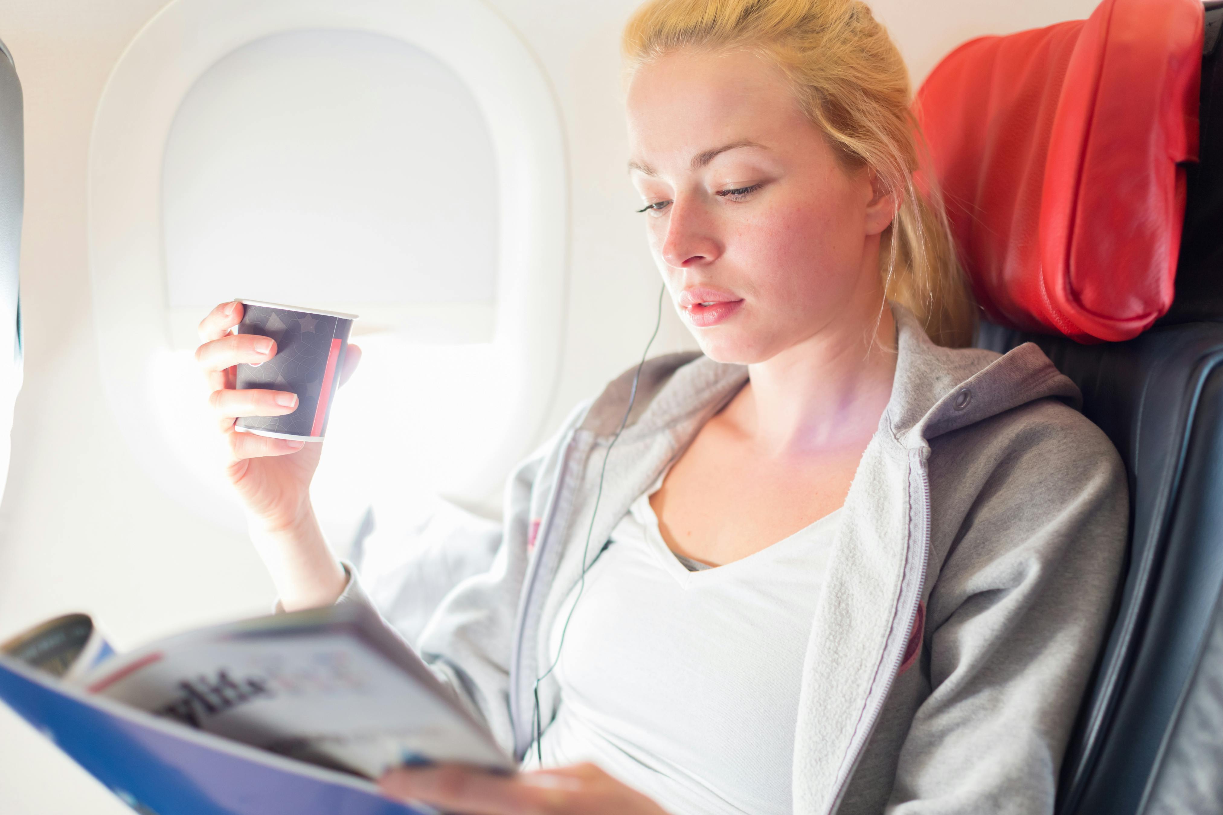 Det er helt almindeligt at få propper i ørene, når du er ude og flyve. En kvinde sidder i et fly med propper i ørerne
