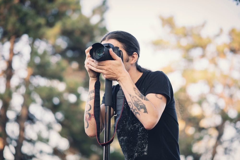 Fotograf med enbensstativ, kallat monopod, fotograferar djur i naturen