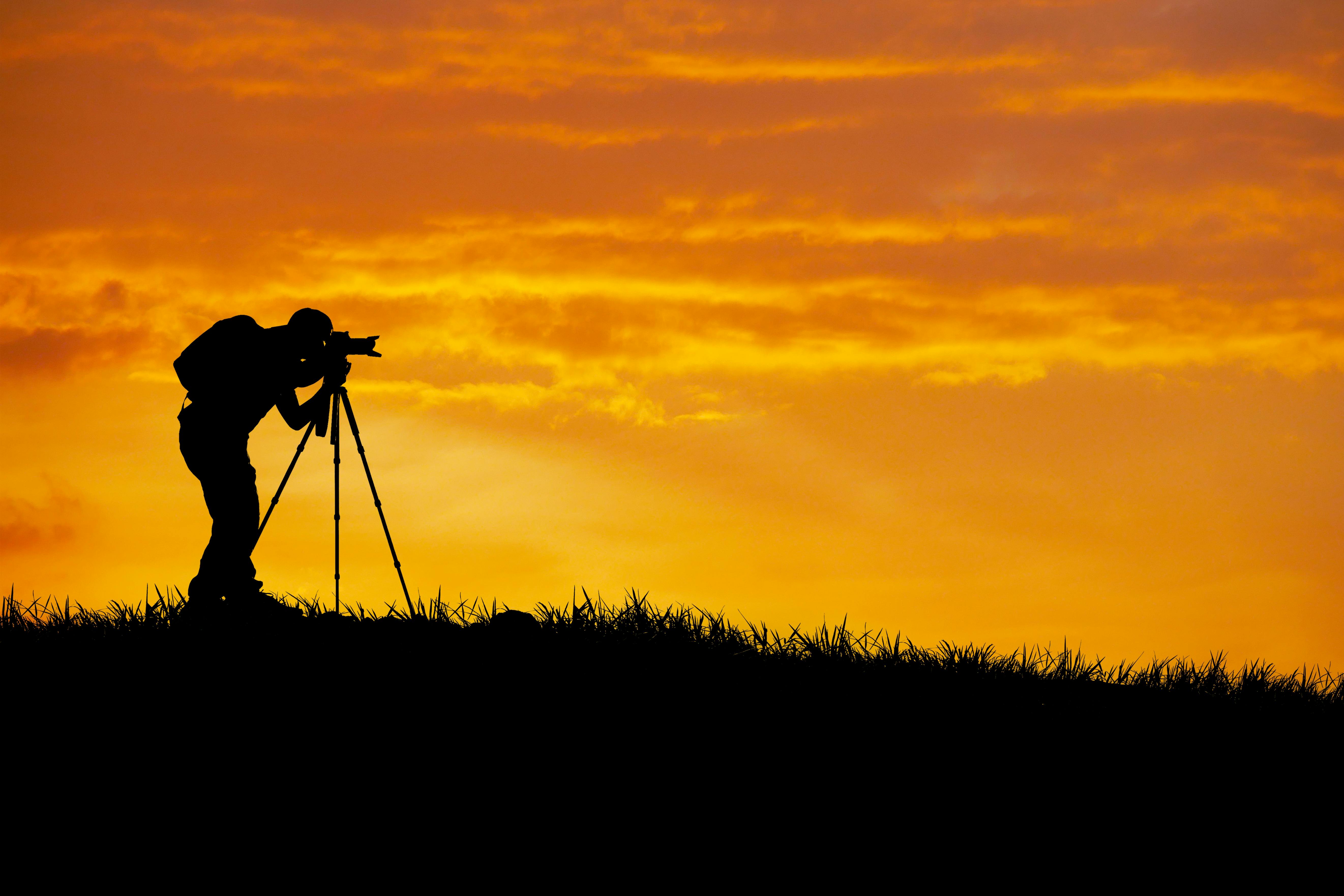 På flekken Fotograf fotograferer landskap i solnedgang
