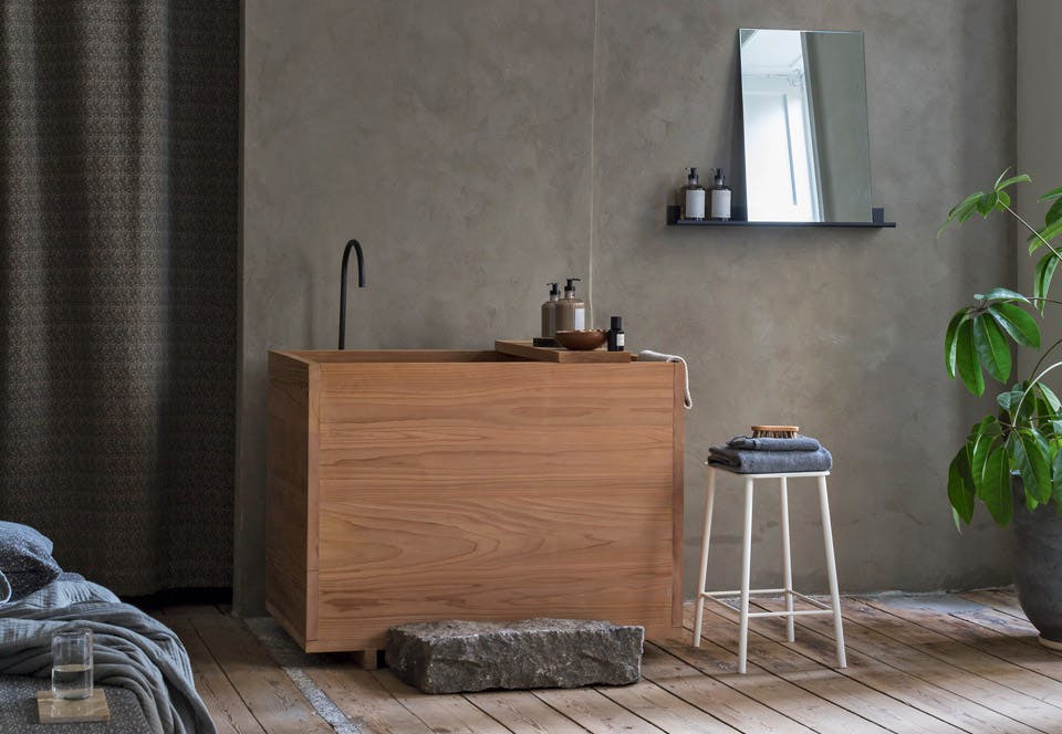 Japans houten bad in scandinavische badkamer met ruwe vloer