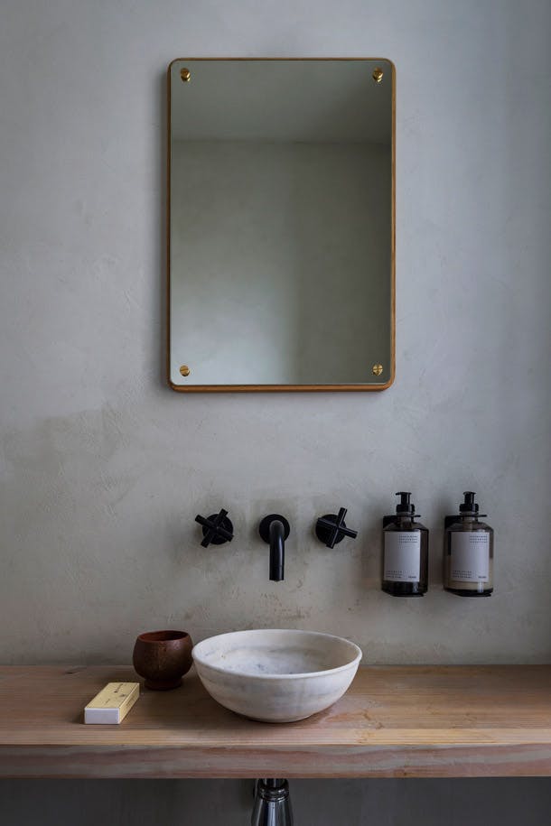 De wastafel is van Frama en de kraan van Dornbracht. De zeep in gele verpakking is van Skagerak. Losse Scandinavische Frama wastafel op houten blad