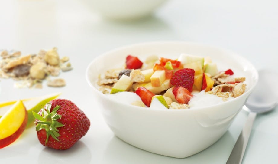 Antioxidanter redan på morgonen. Naturell Cultura med to stykker frukt og grov mysli