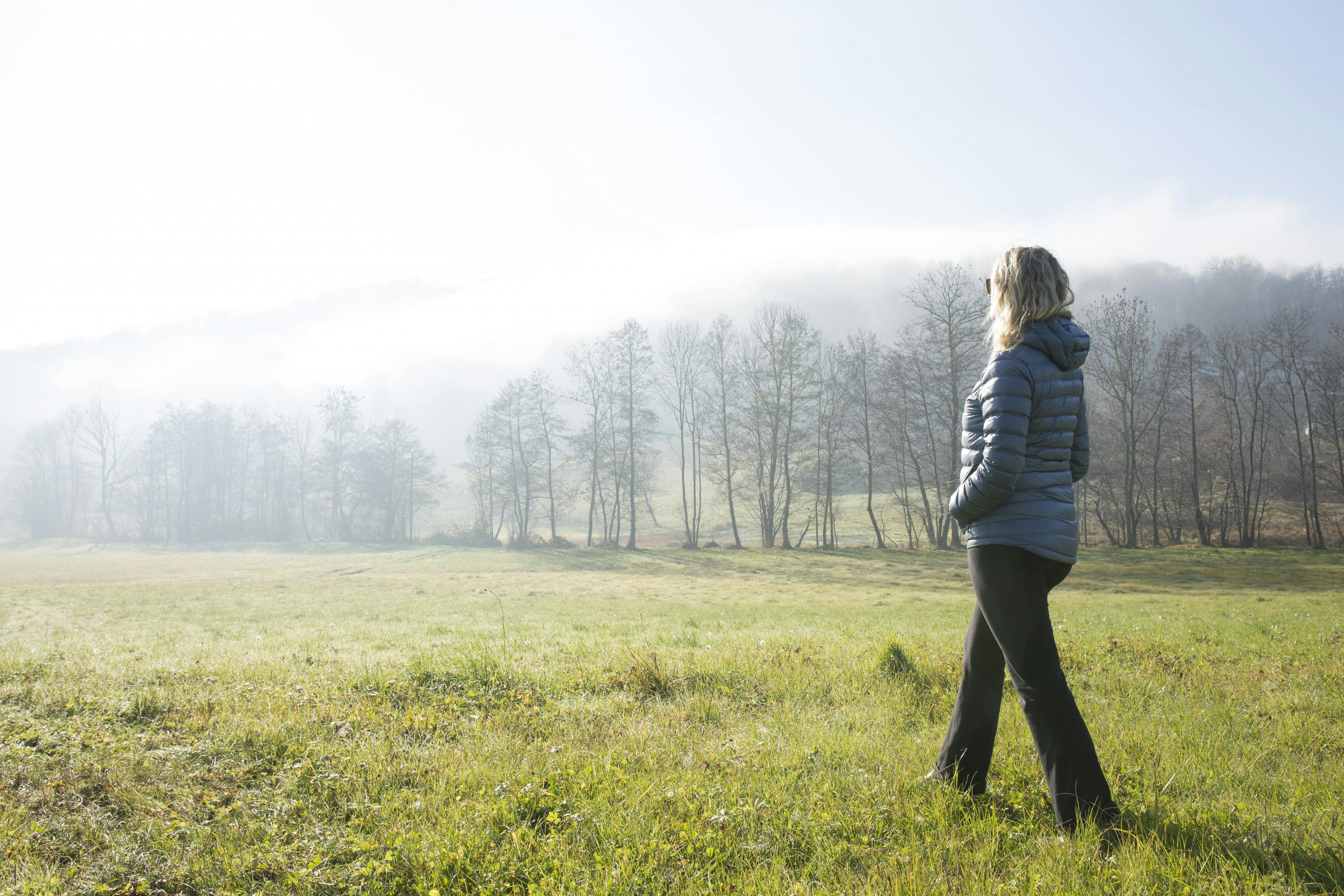 Du kan gå dig rolig og slippe af med stresssymptomer. Moden kvinde går en tur i naturen