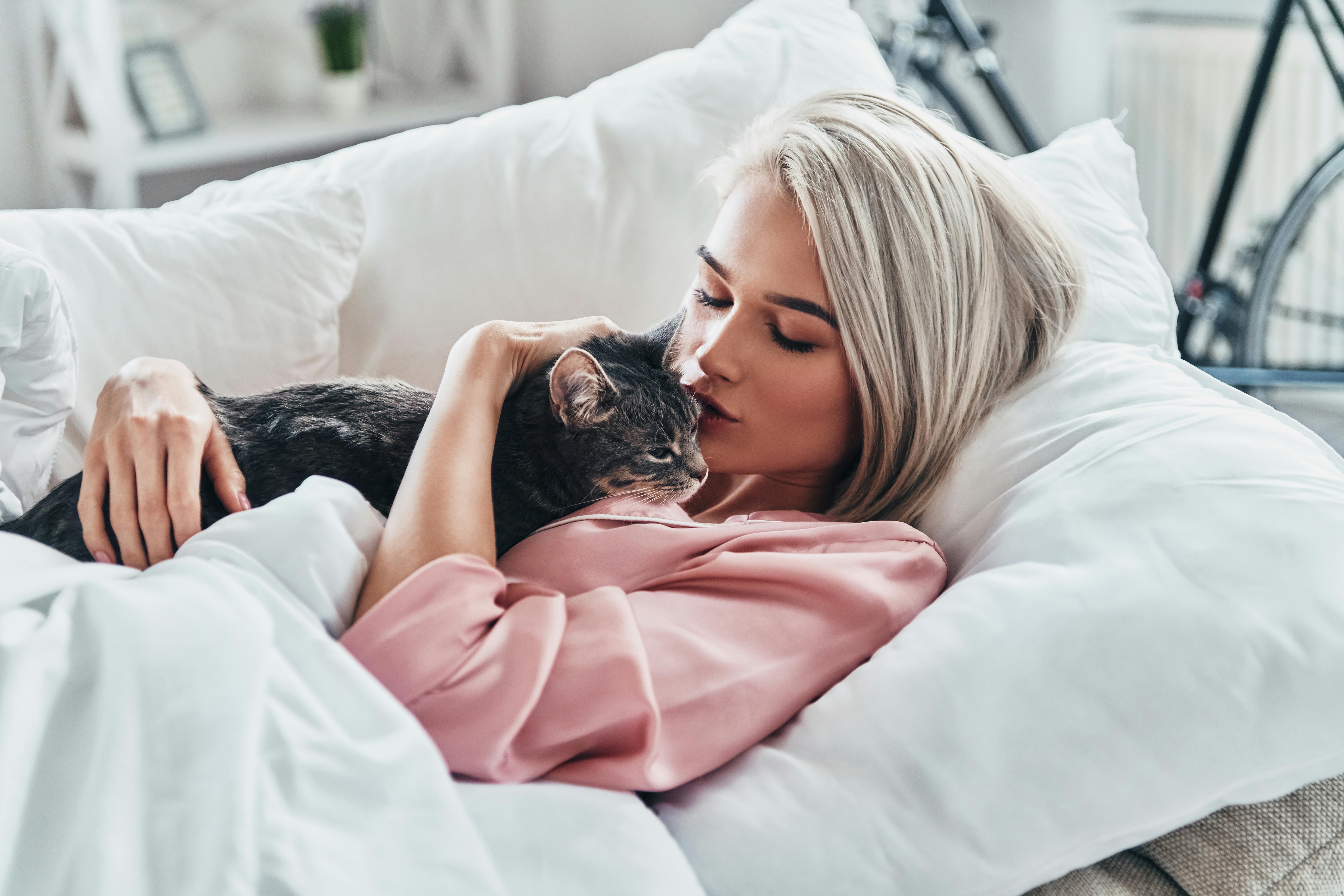 Find et godt kattenavn til din nye puttemakker. kvinde med kat på sofaen