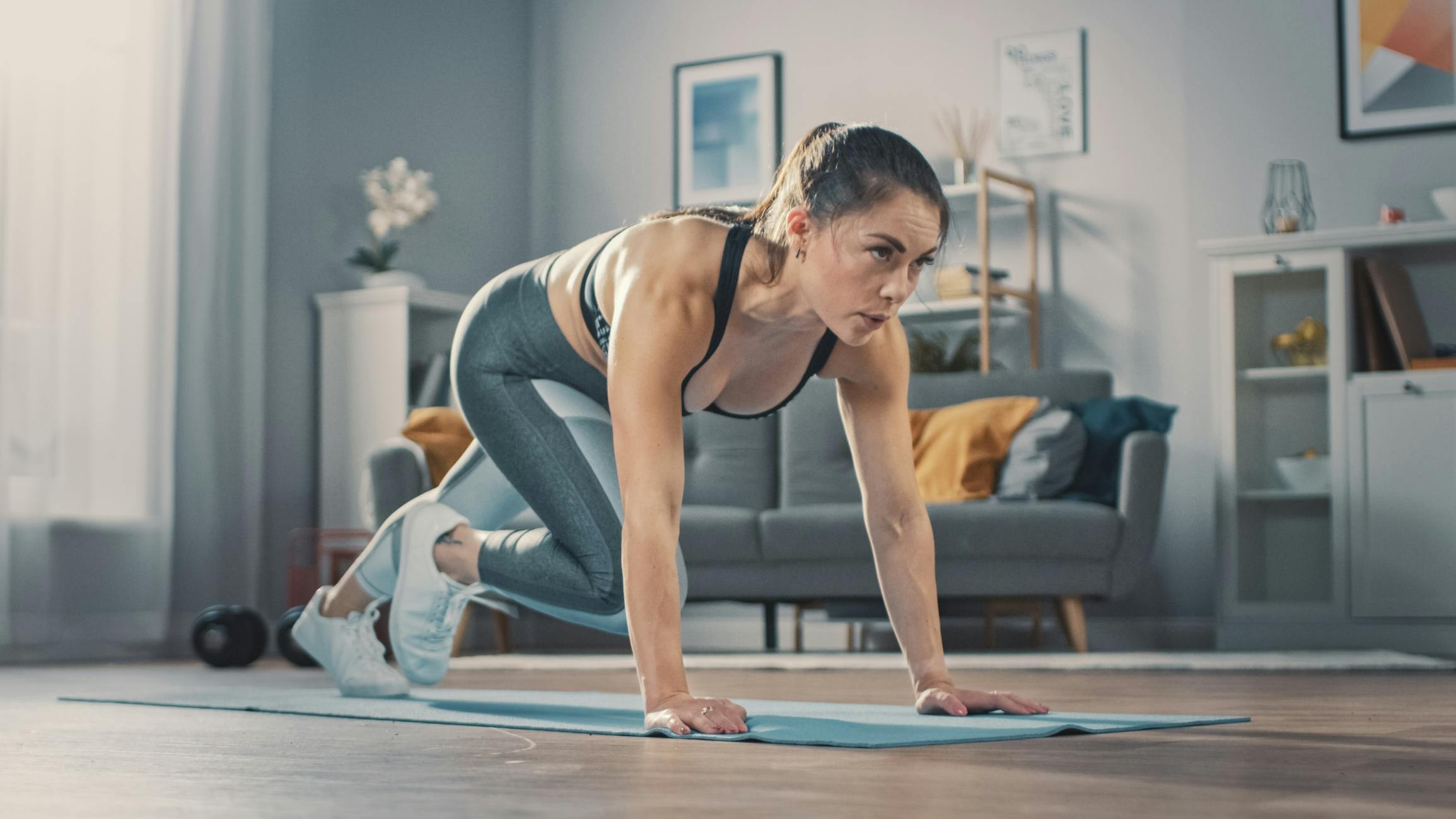 Fjellklatrere Kvinne tar fjellklatrere på yogamatte i stua