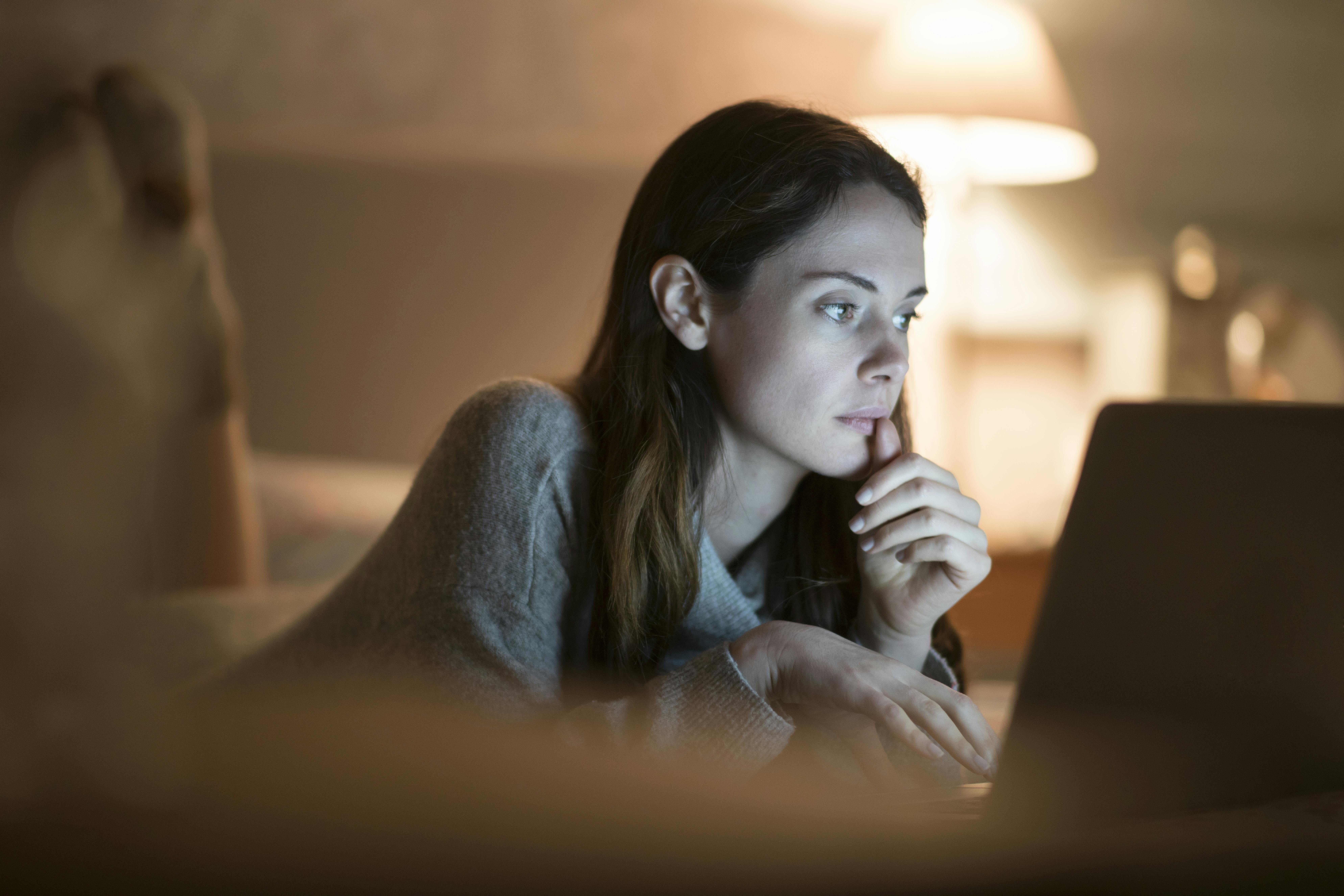 En perfektionist vil gøre alting grundigt – både i forhold til job, studie, udseende og sociale relationer. Kvinde ligger foran computer i seng