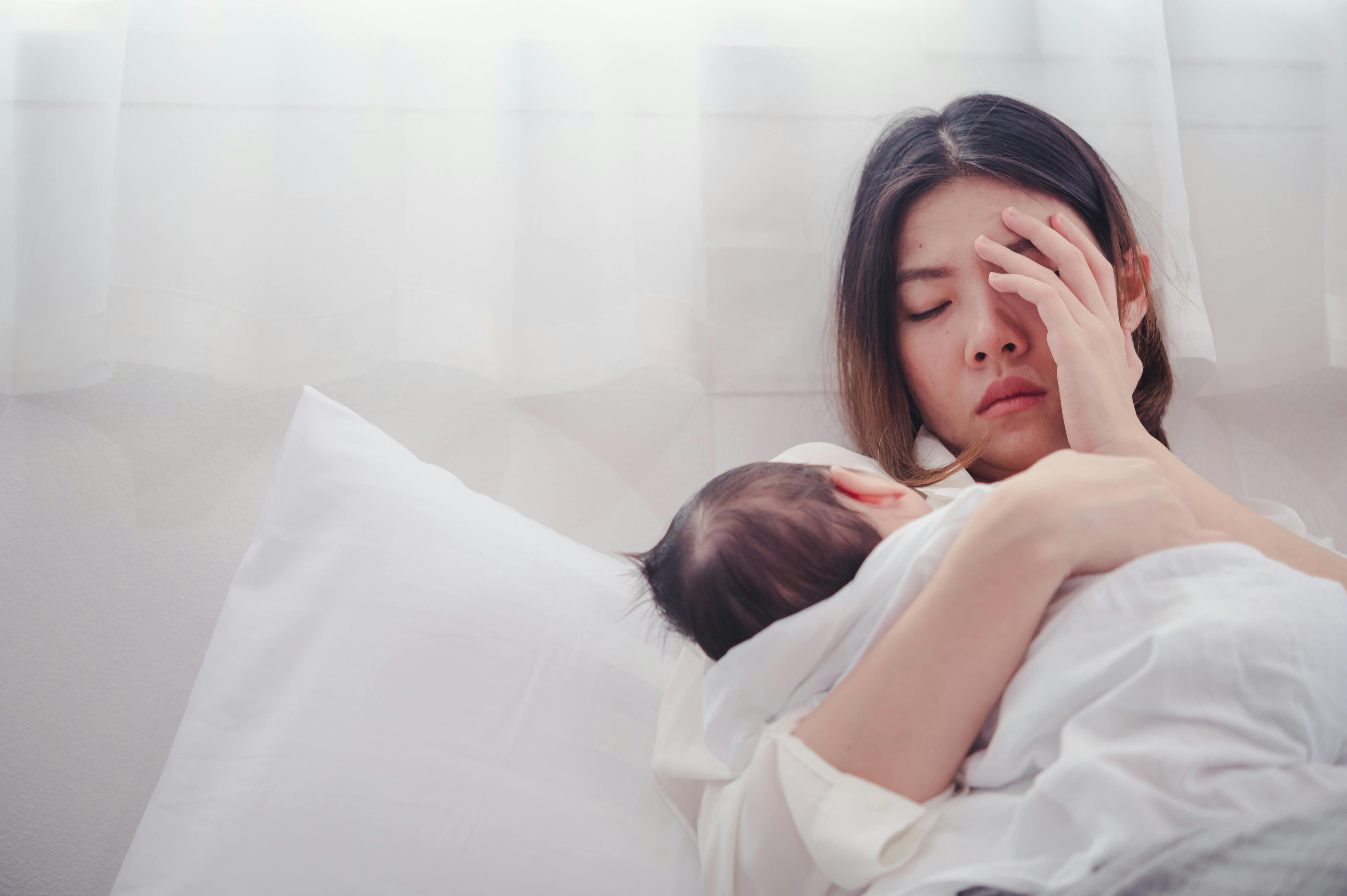 Ved en fødselsdepression står symptomerne på over en længere periode. Træt mor med baby