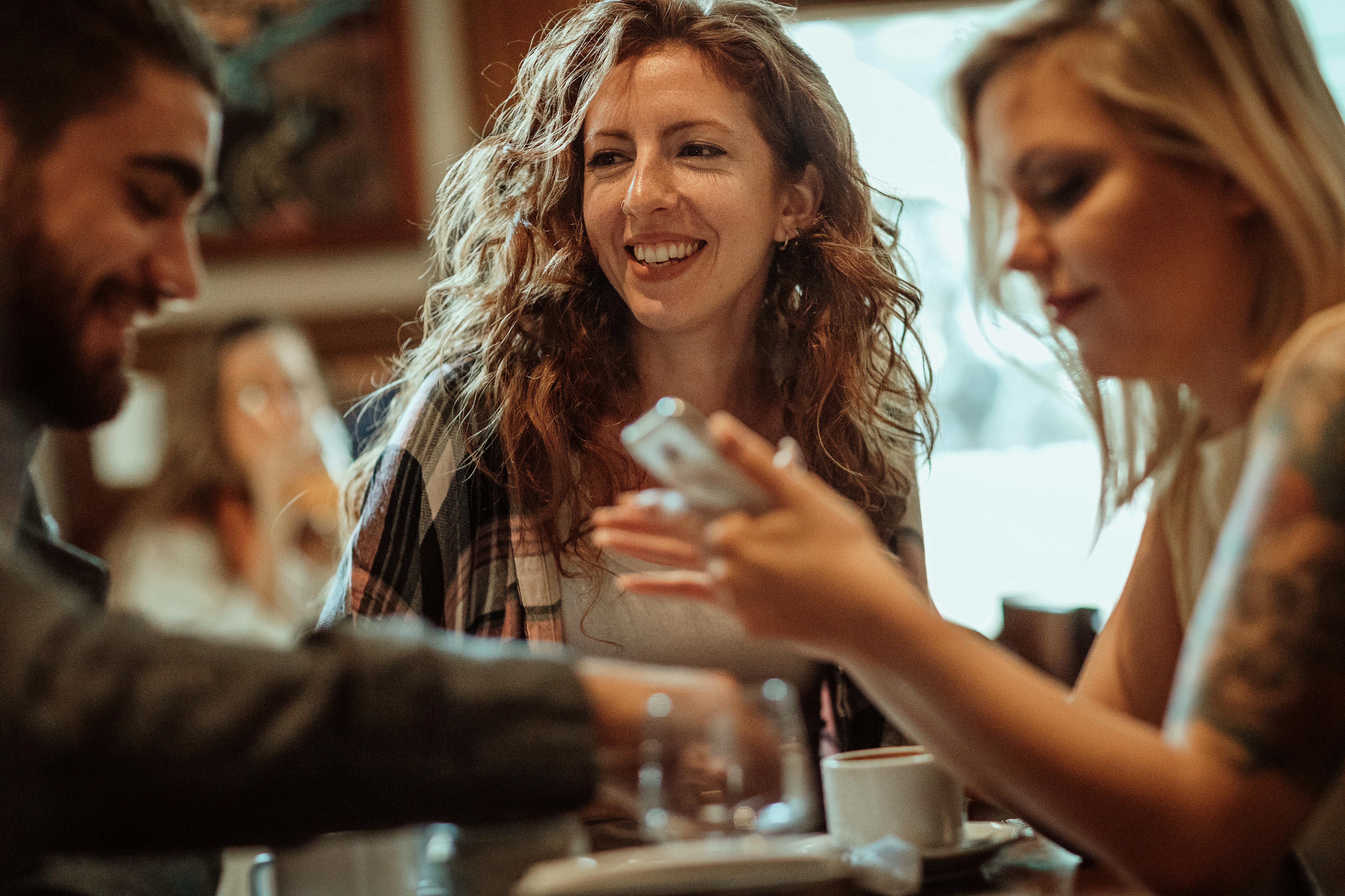 Tre personer sidder på en cafe