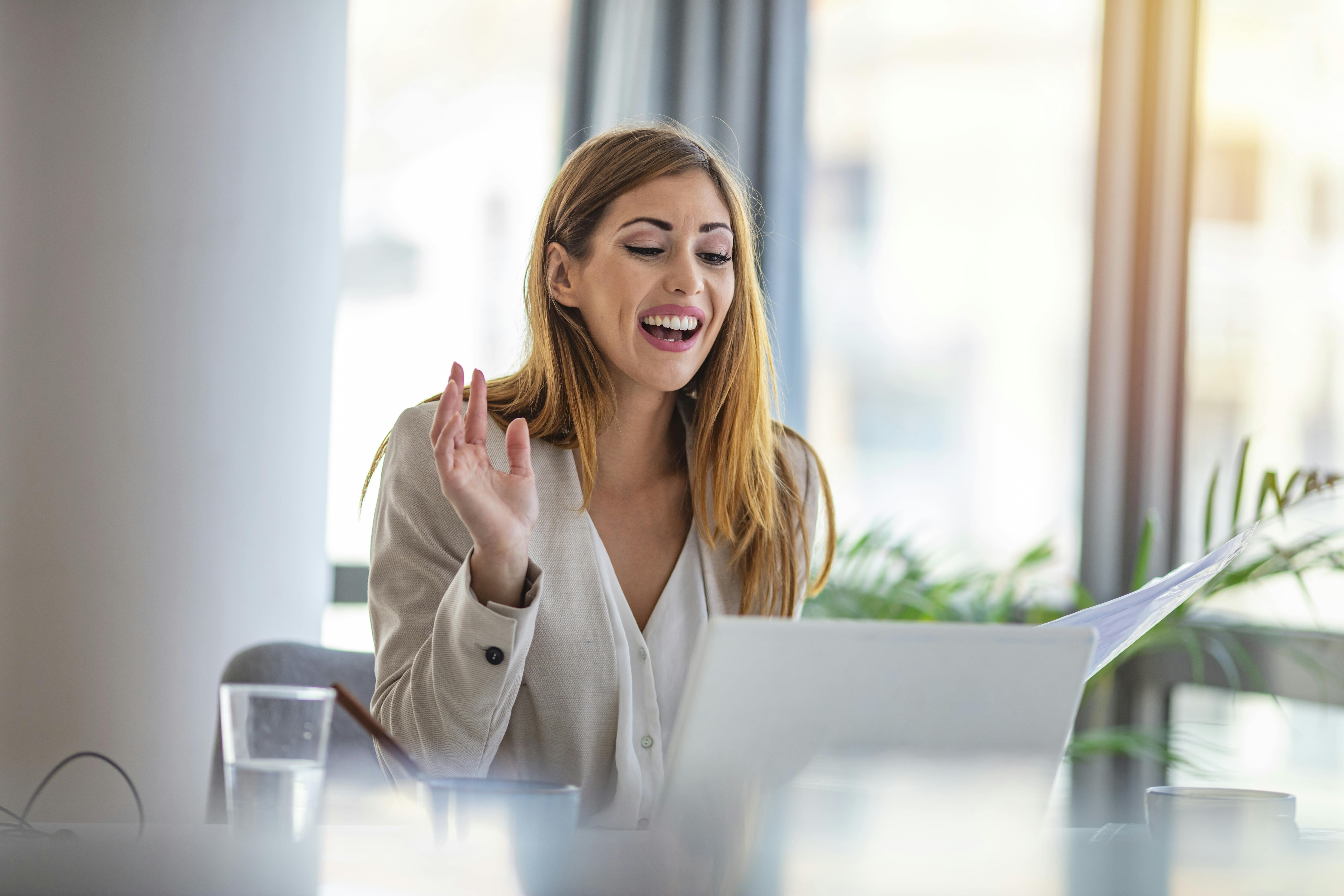 En god idé kan være at tjekke teknikken i god tid inden den virtuelle jobsamtale. Kvinde sidder foran computer og taler