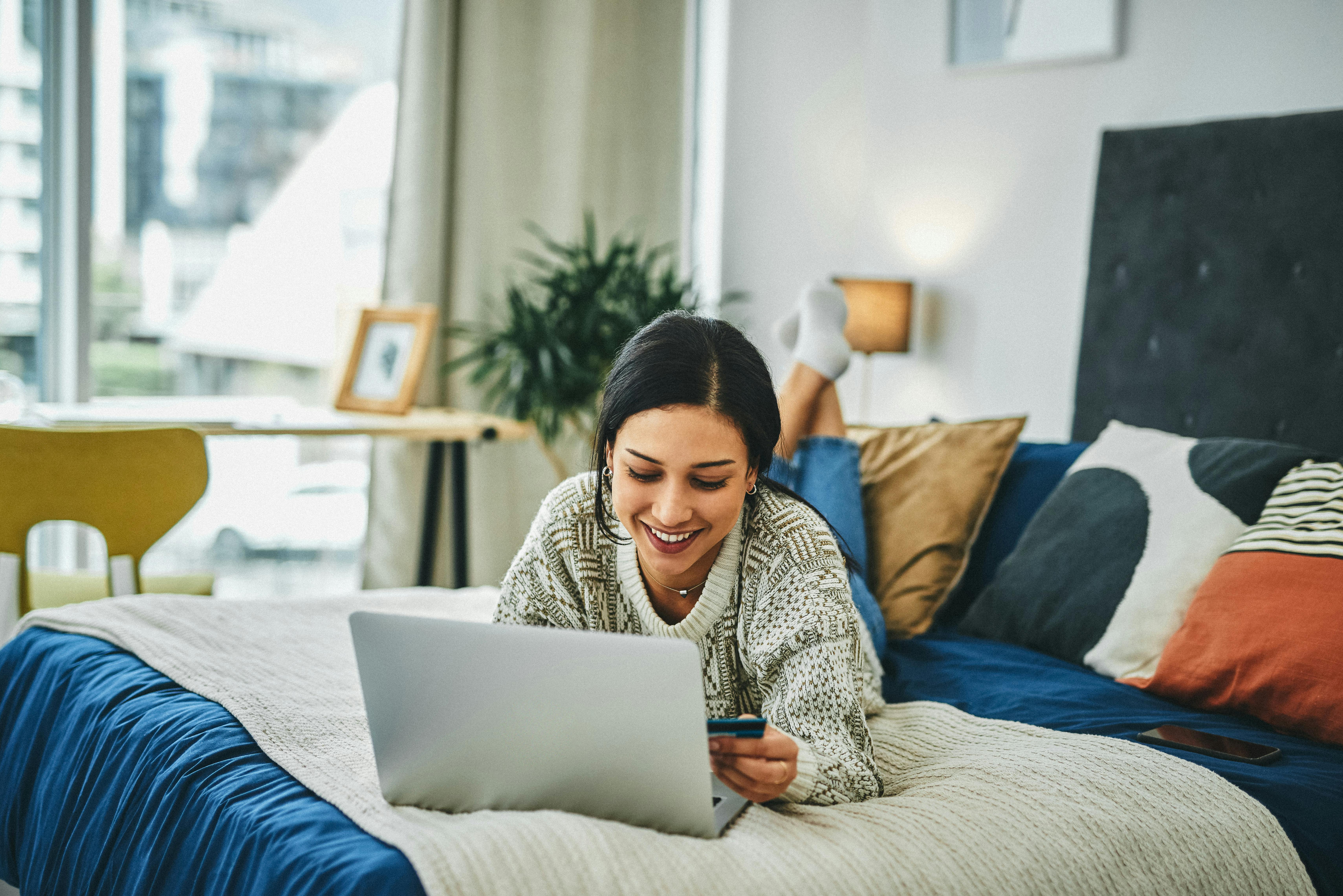 Er en kold regnvejrsdag ikke den perfekte anledning til at shoppe varme sweatre på nettet? Pige ved computer
