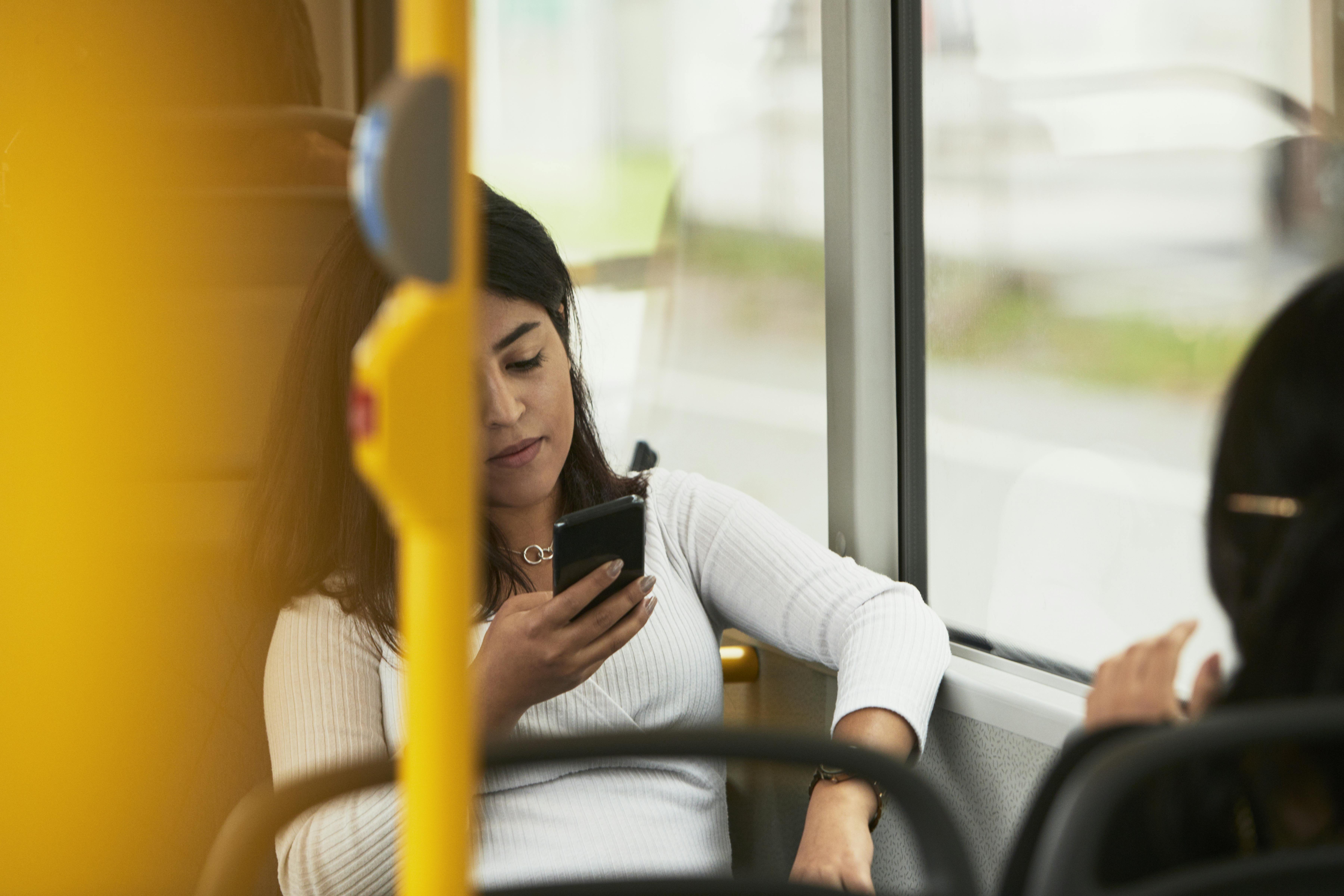 Læg telefonen i lommen, når du tager offentlig transport. Kvinde i offentlig transport