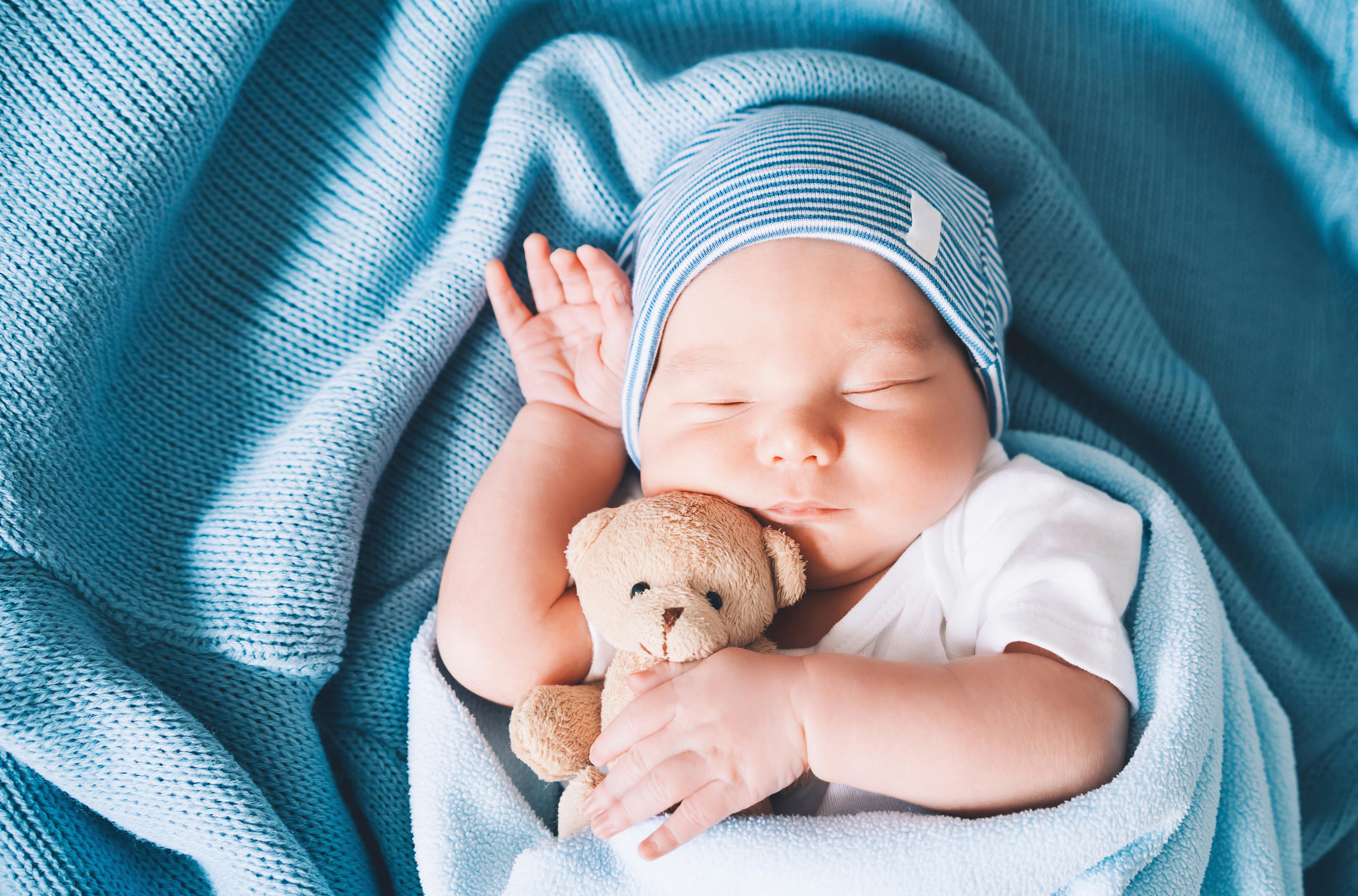 Små babyer er meget imponerende! Nyfødt baby holder om bamse