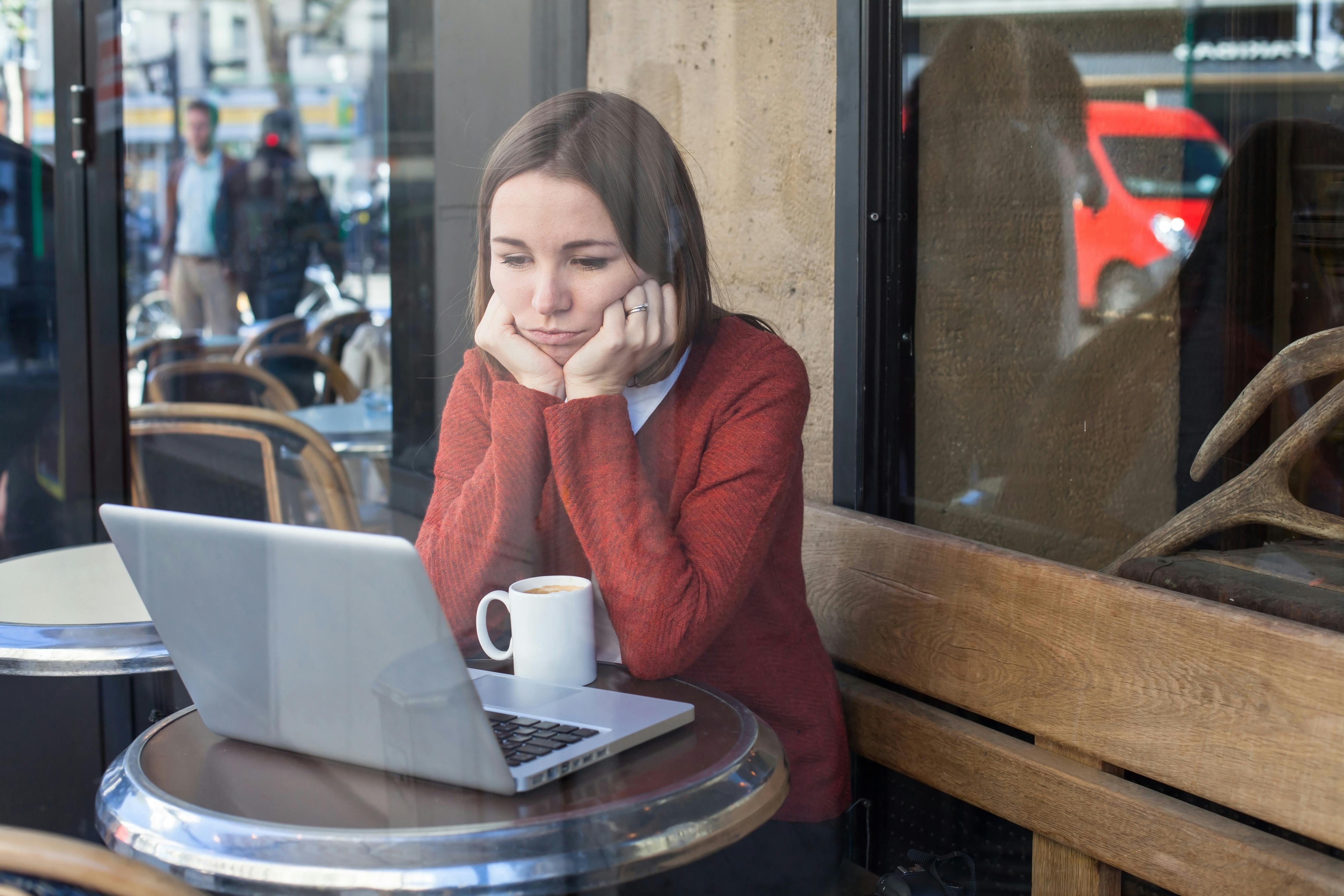Du kan hurtigt ende med at føle dig snydt, hvis ikke du passer på, når du dater online. Kvinde der sidder på en café