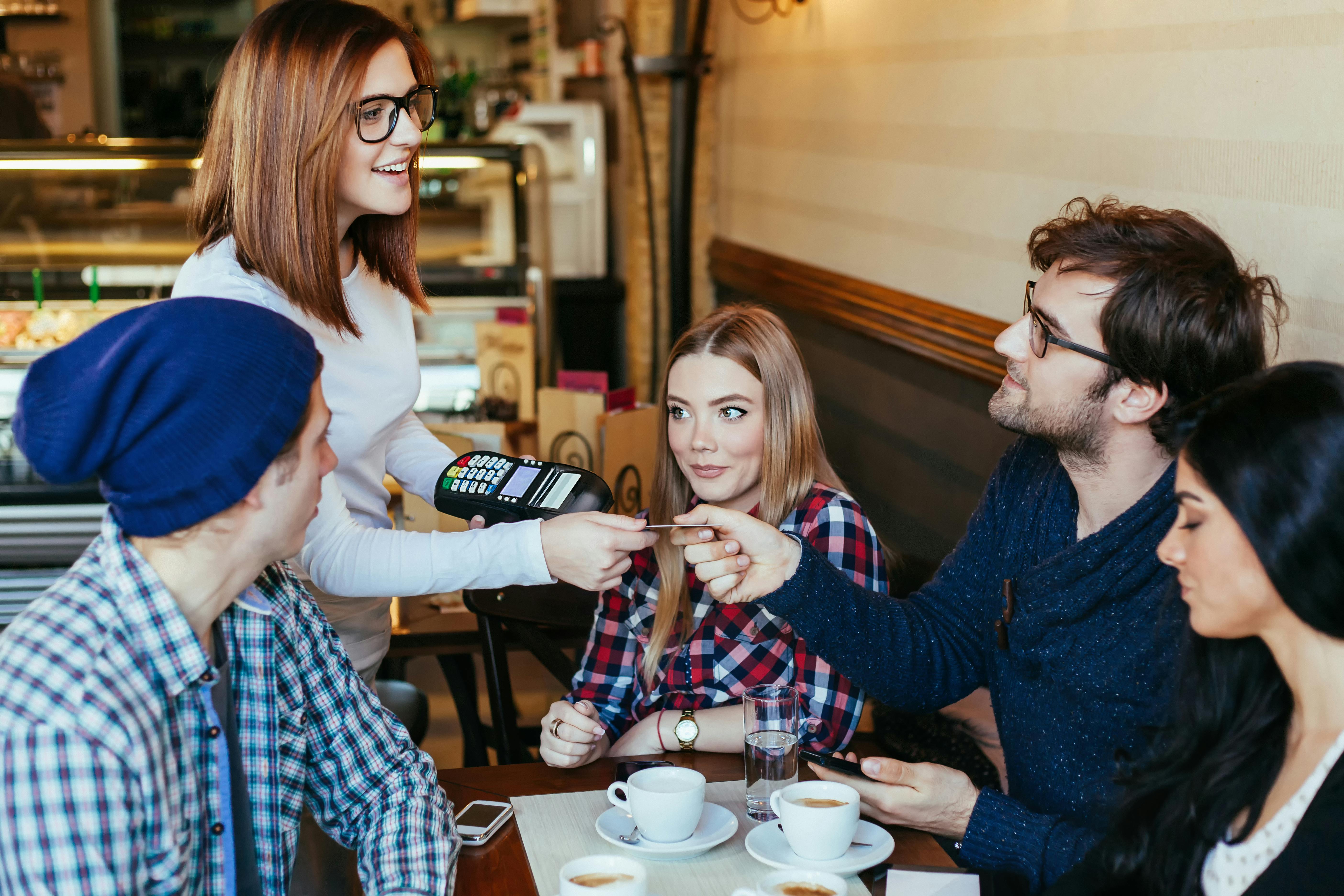 Er det altid din kæreste, der hiver kortet frem, når der skal betales? Mand betaler på en café