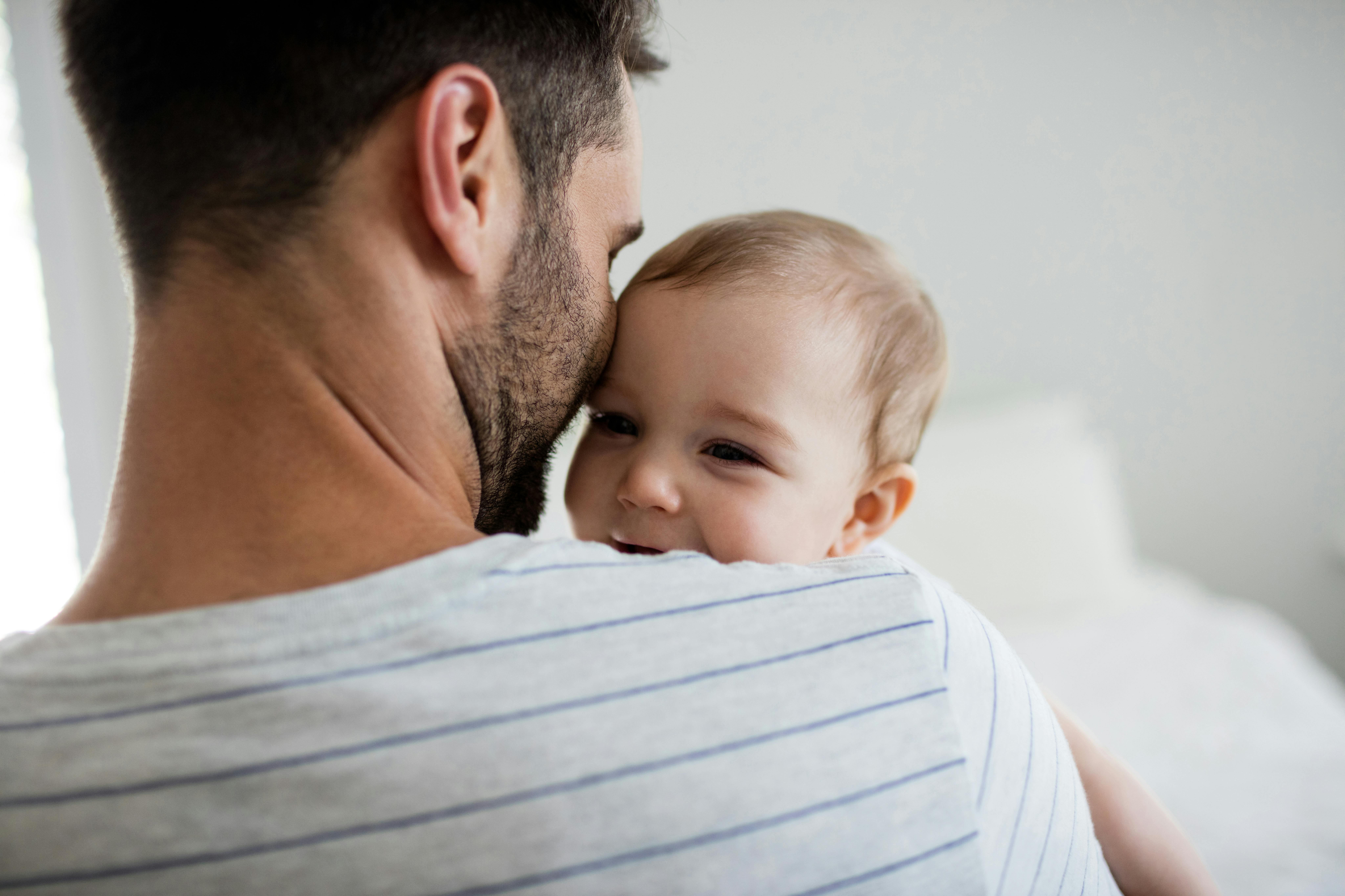 Vidste du, at far har krav på to ugers ferie efter fødslen? Far holder baby i armene