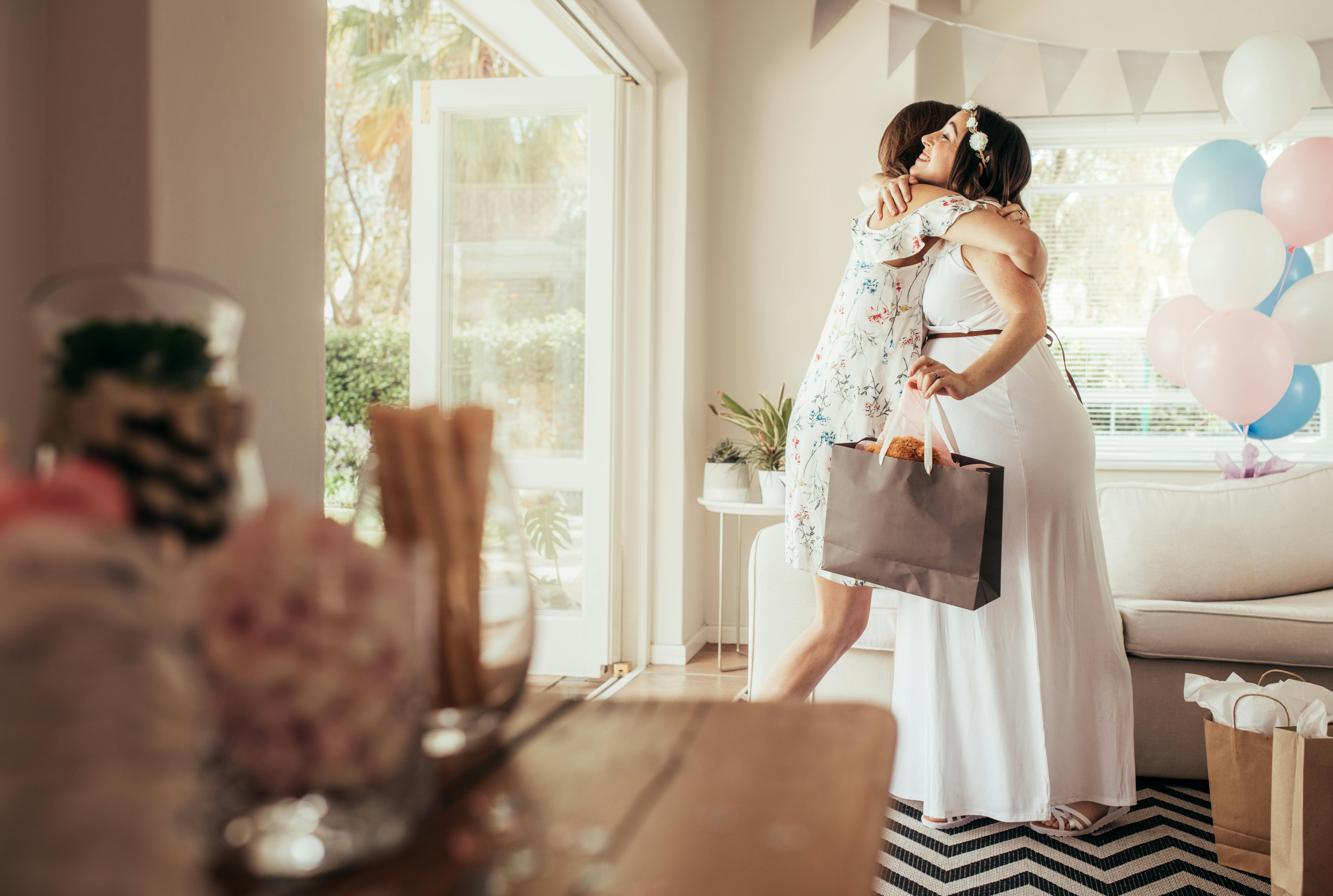Spørg din gravide venindes veninder, om de vil være med til at planlægge babyshower. Veninder der krammer hinanden til babyshower