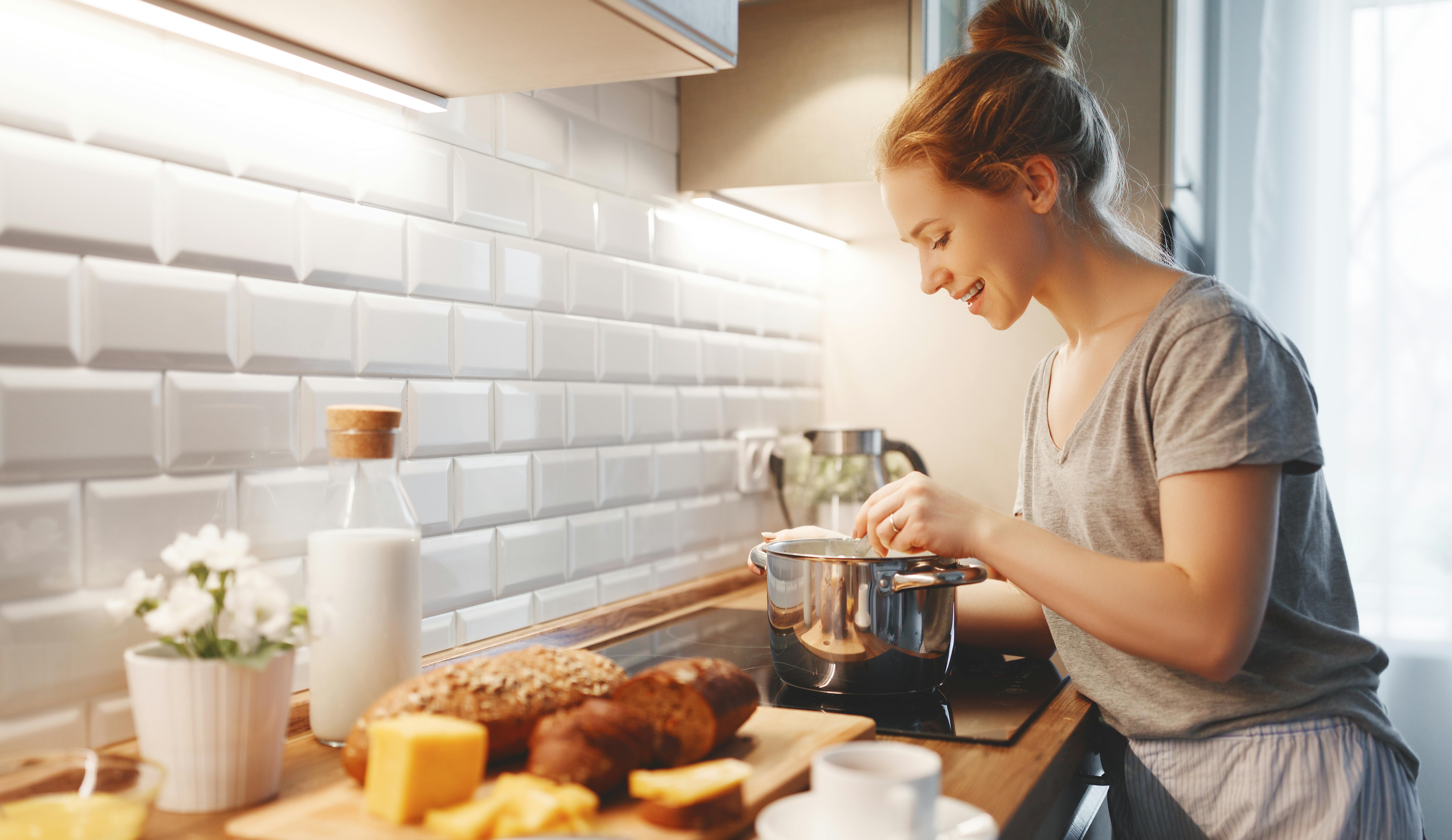 Du kan også overraske din kæreste med en lækker morgenmad. Kvinde laver morgenmad til sin kæreste