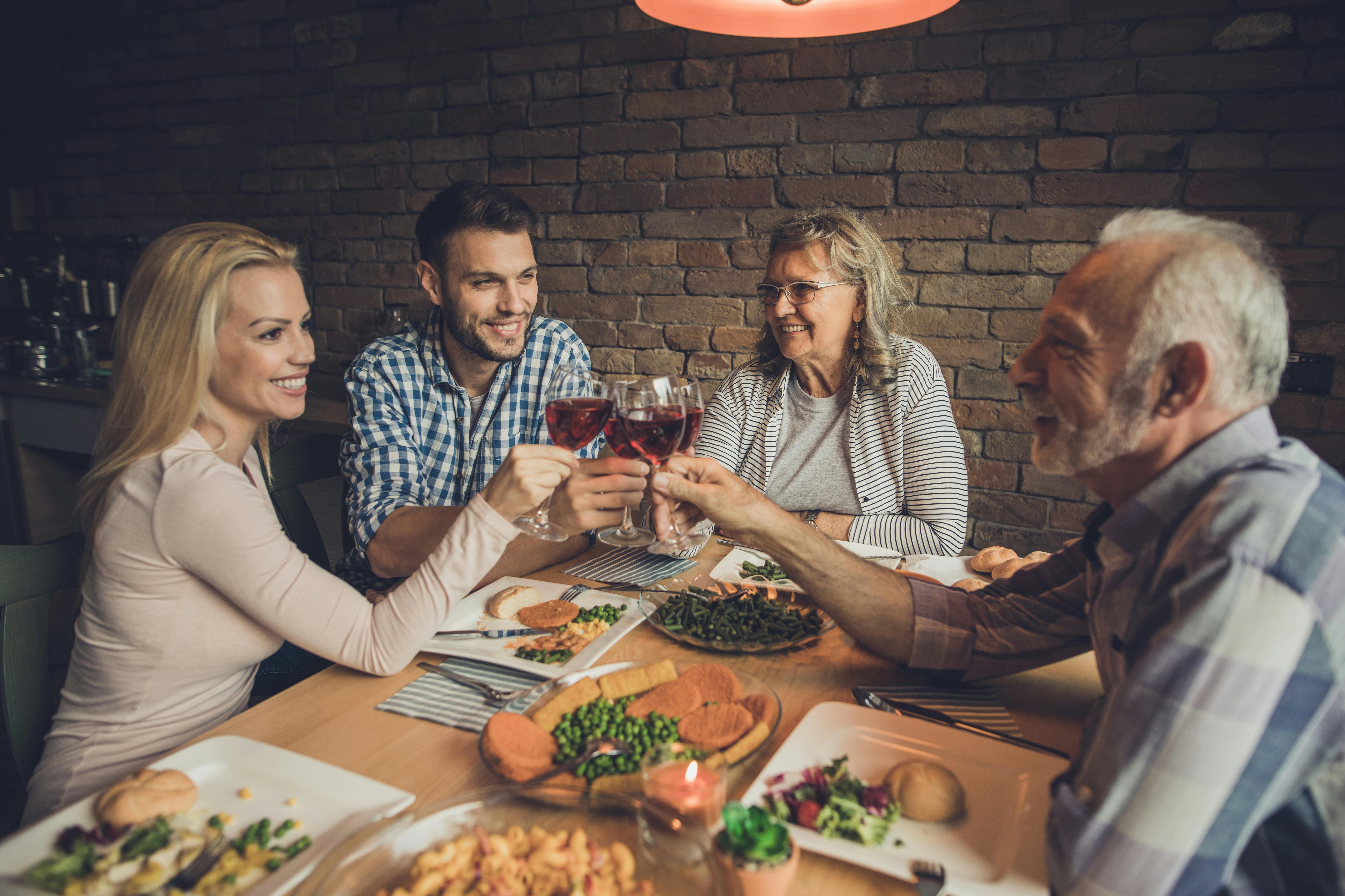Tjenere kan virkelig stable mange tallerkener på samme arm. Familie spiser middag.
