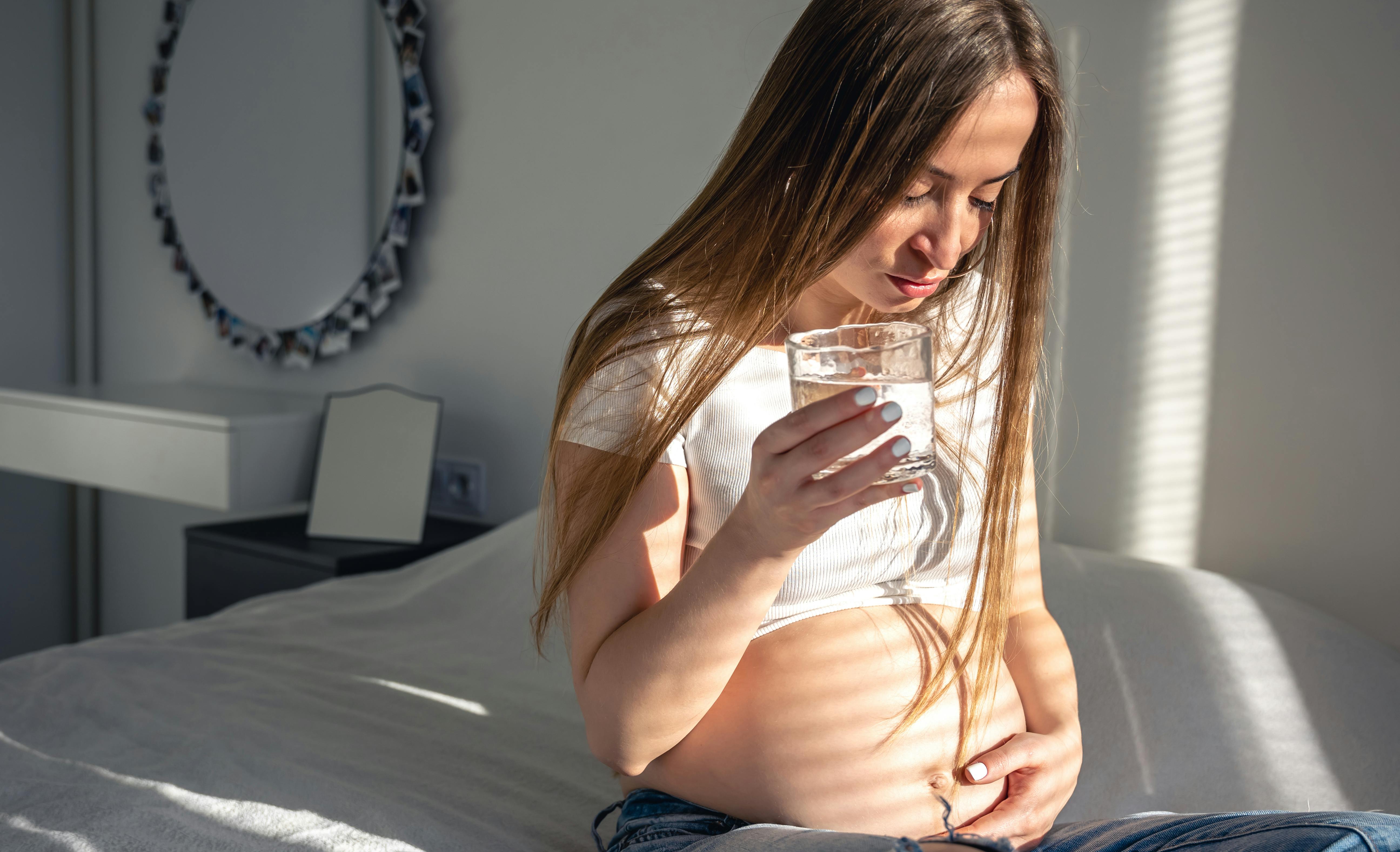 I uge 20 af graviditeten får fostret søvnfaser. Kvinde, der er gravid i uge 20, ser på sin mave