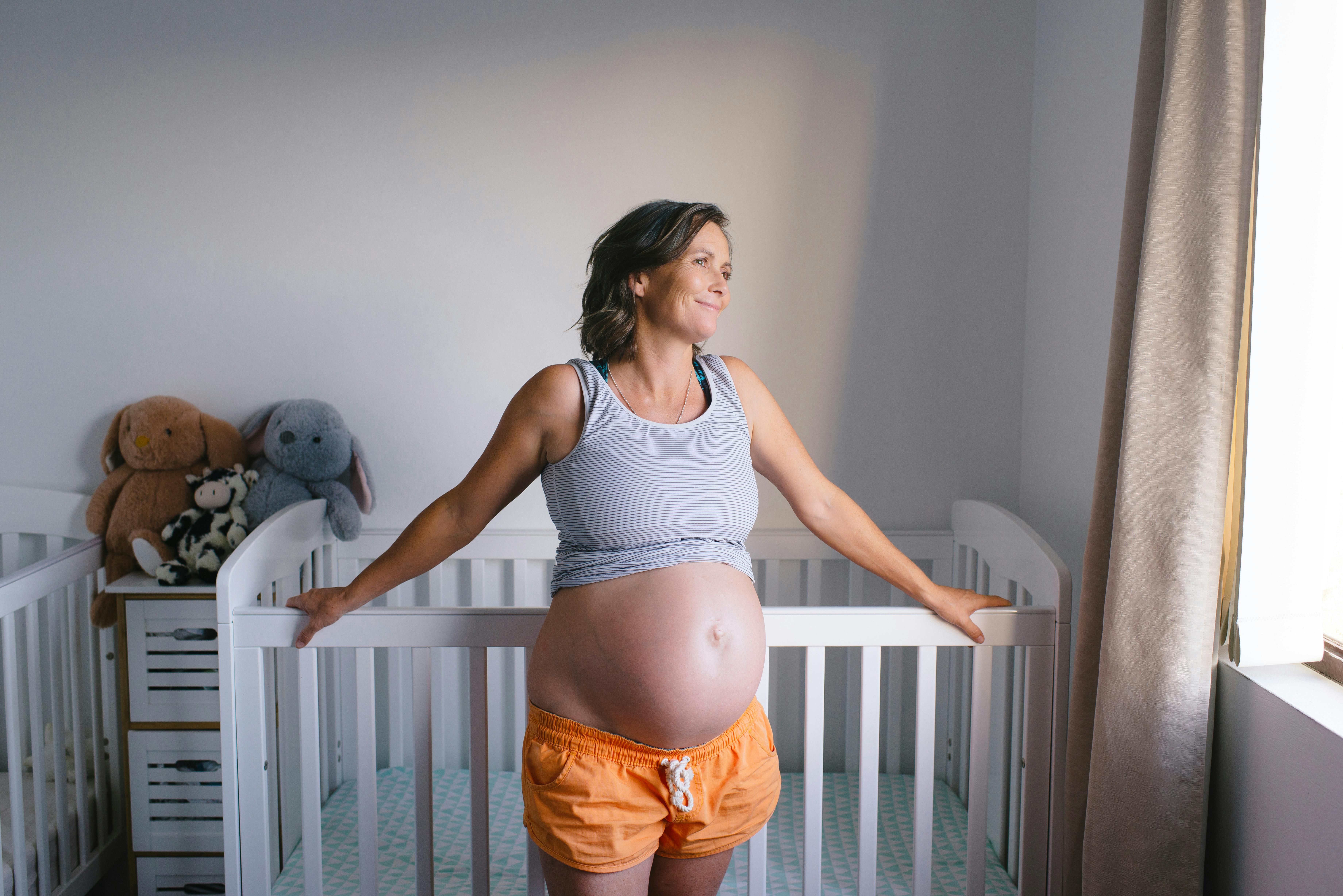 Fostrets ansigt begynder at se ud som ved fødslen her i uge 35 af graviditeten. Kvinde, som er gravid i uge 35, står ved en tremmeseng