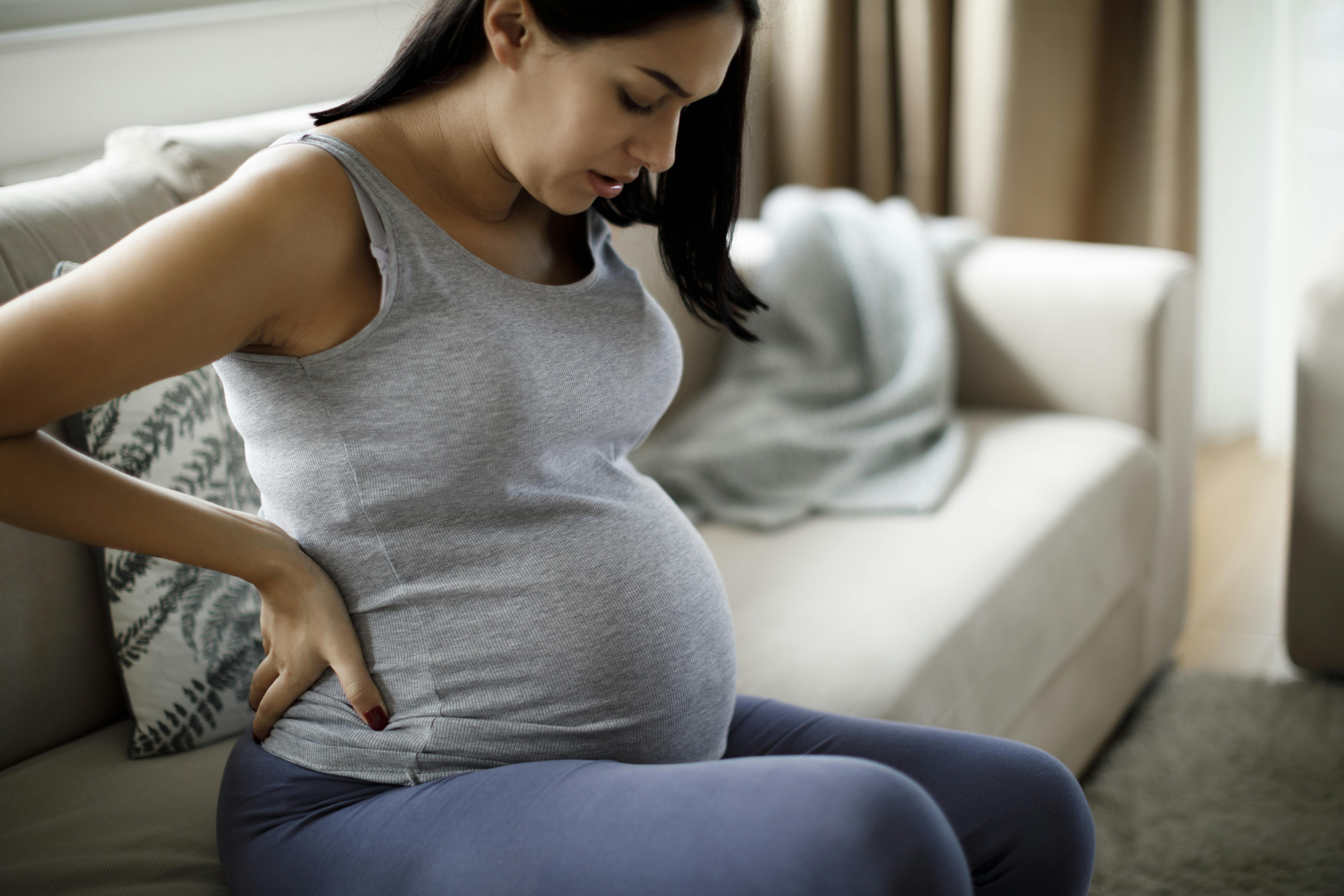 Du kan ikke længere føde for tidligt, når du er gravid i uge 37. Kvinde, der er gravid i uge 37, sidder i sofaen