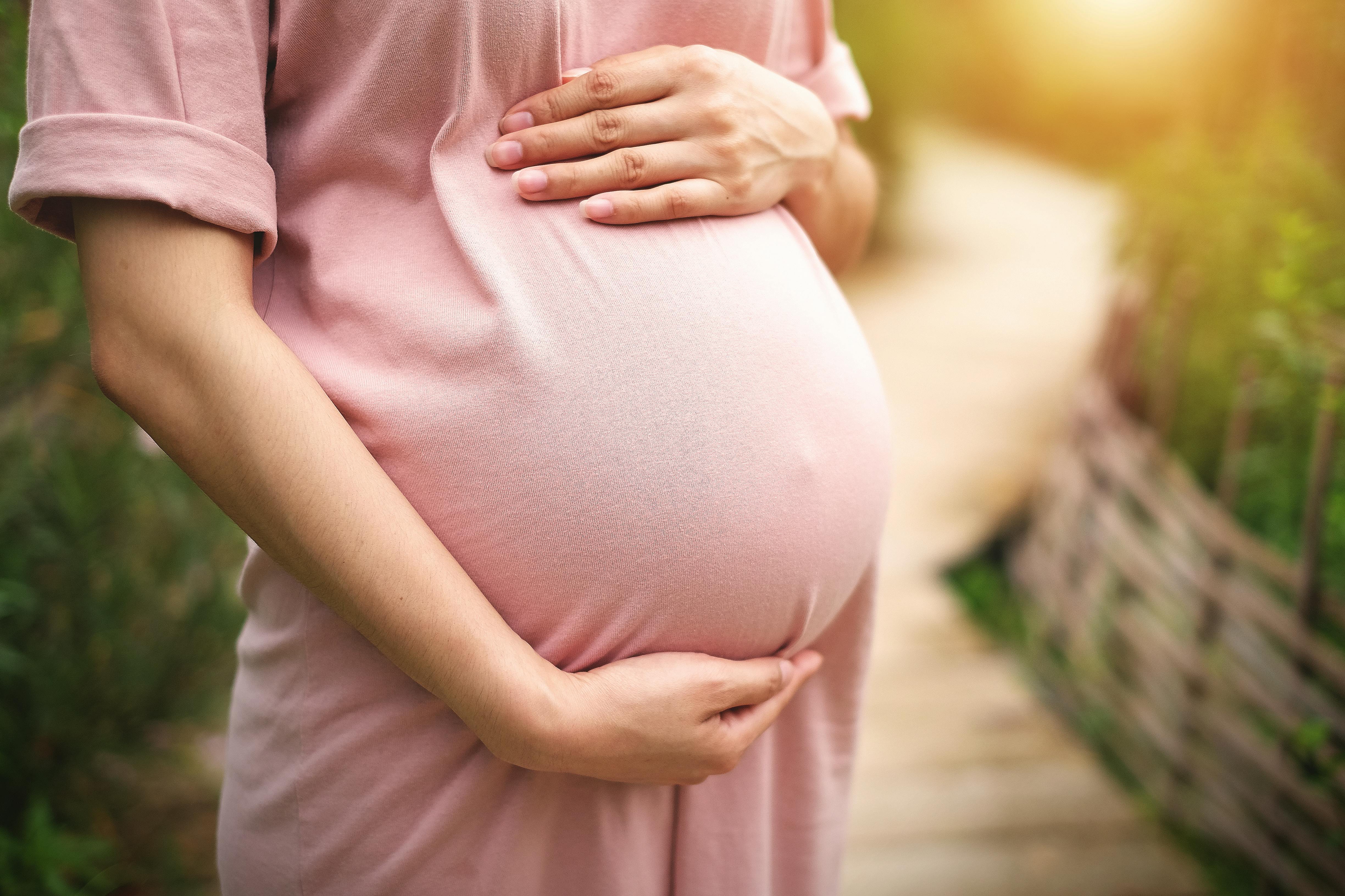 Når du er gravid i uge 27, har fostret bedre chancer for overlevelse ved for tidlig fødsel. Kvinde, som er gravid i uge 27, holder om sin mave