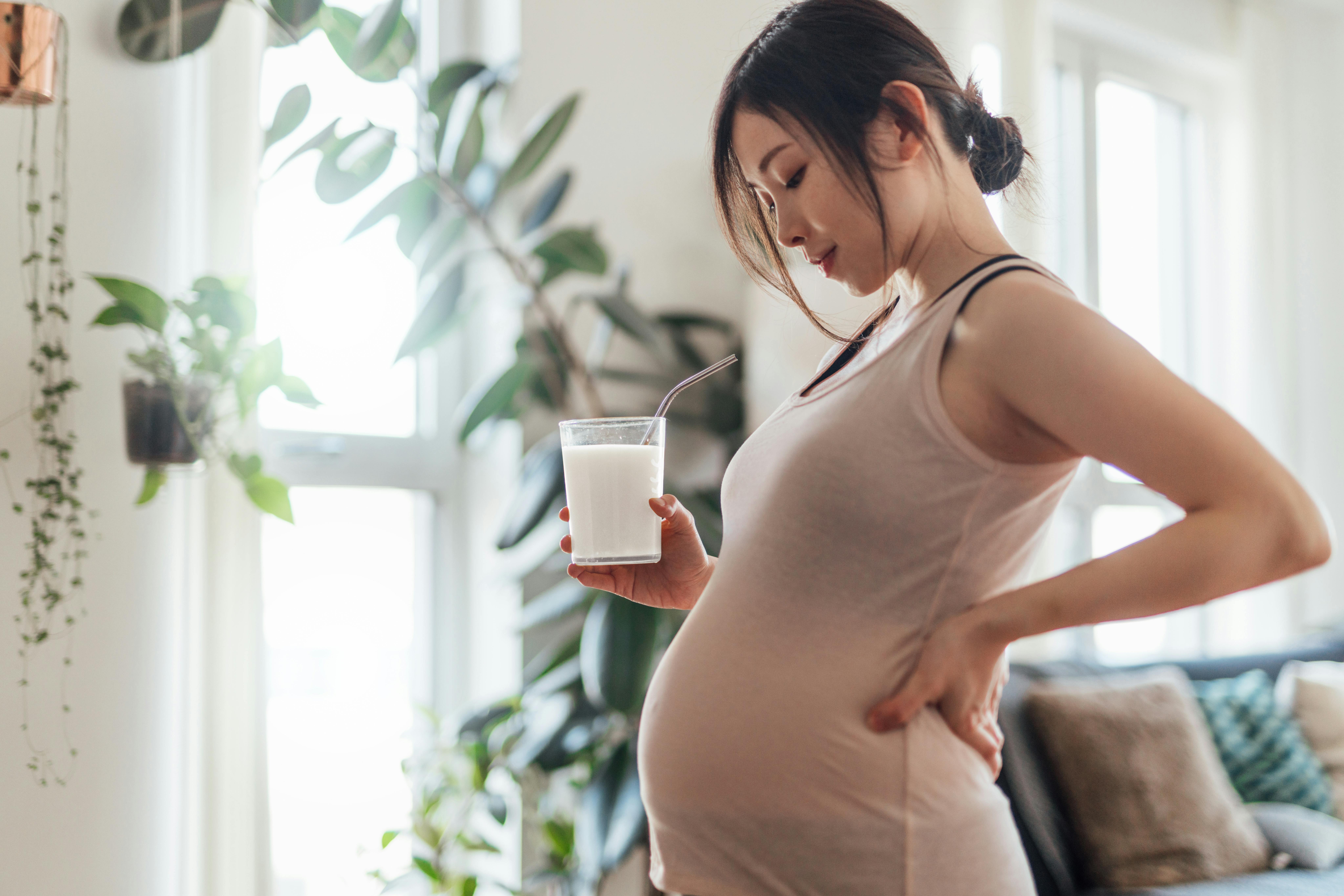 Når du er gravid i uge 19, vejer fosteret omkring 250 gram. Kvinde, der er gravid i uge 19, står med et glas mælk