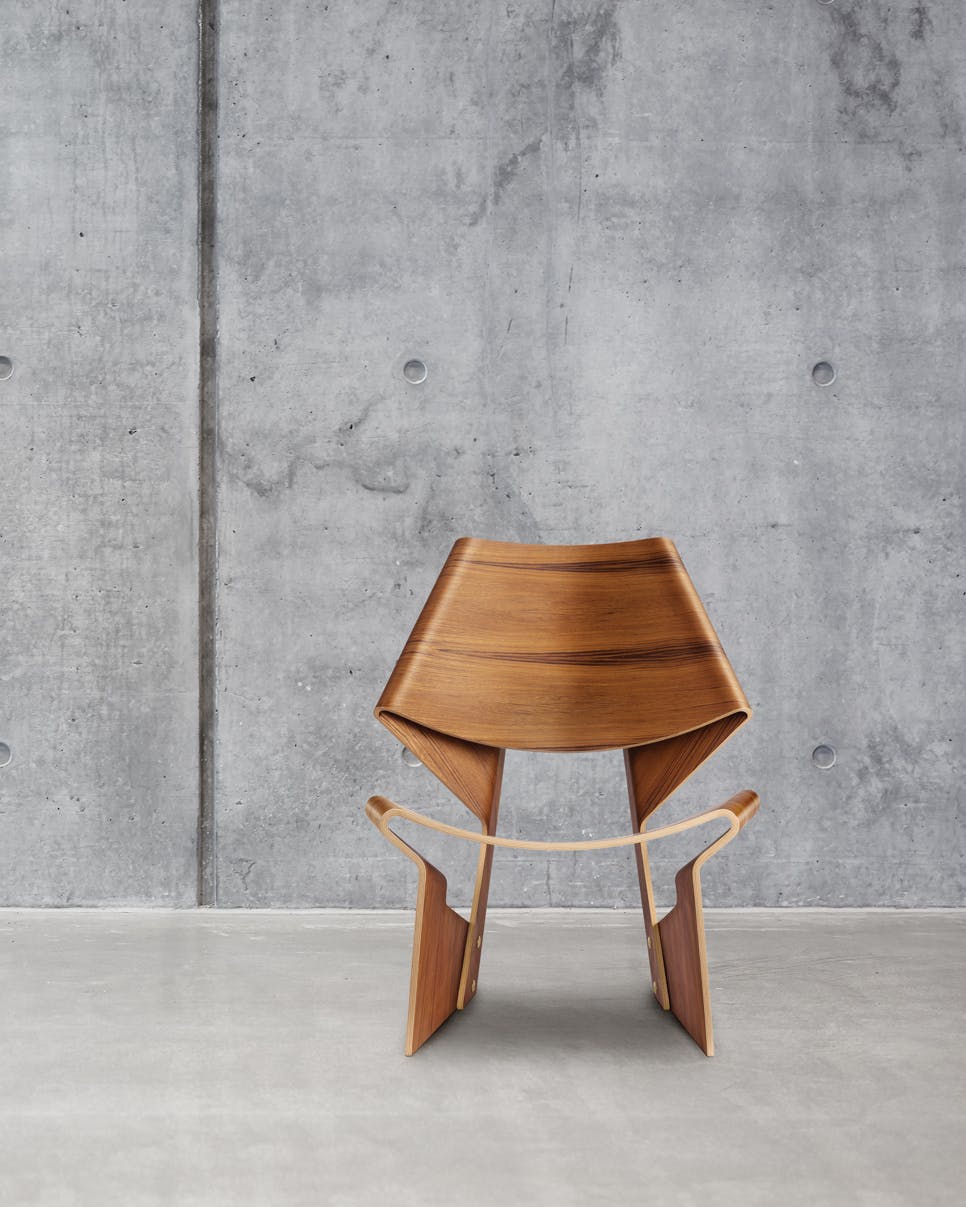 De Bow Chair is in een moderne omgeving nog altijd even relevant. grete jalk bow chair against concrete wall and floor