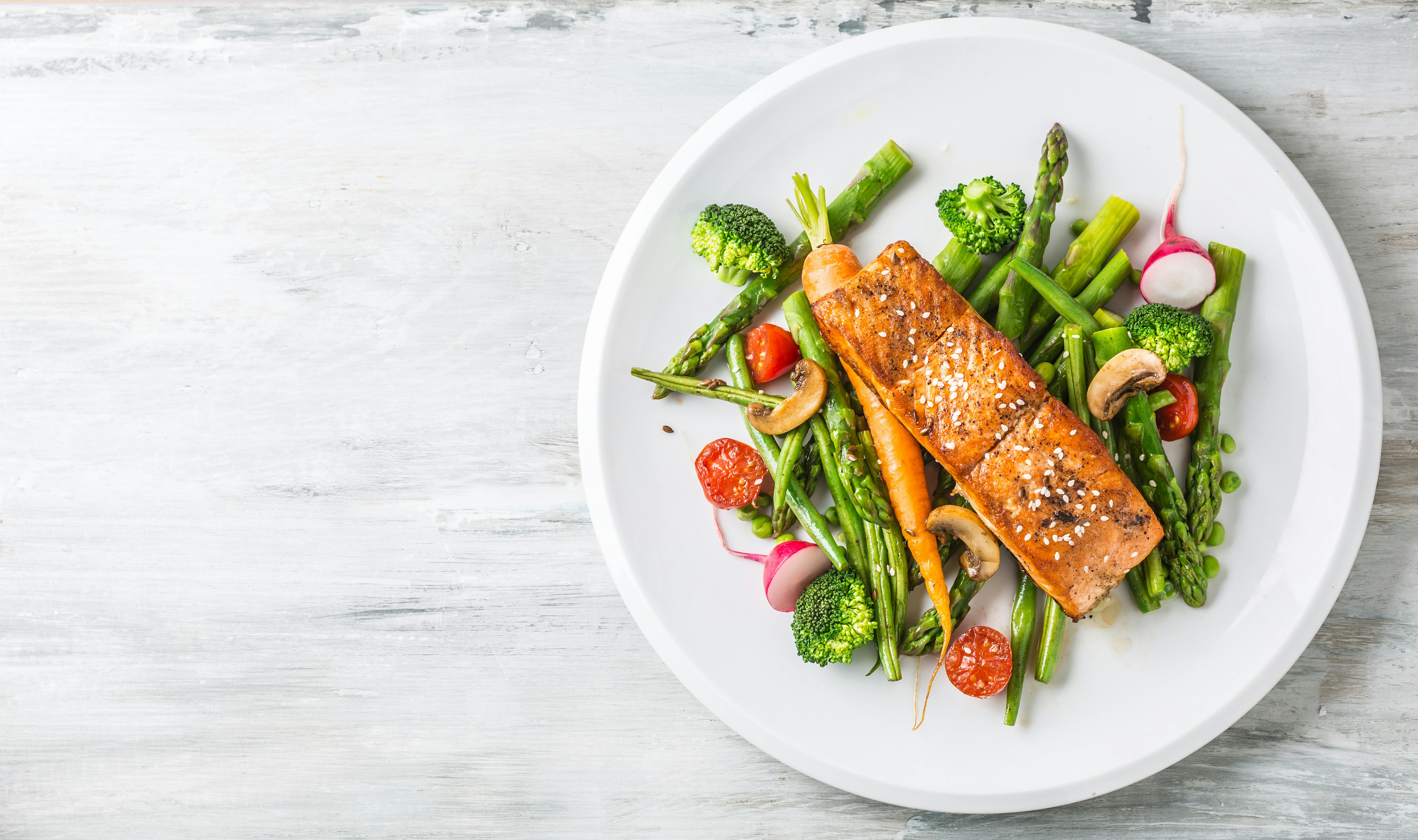 En grøn og antiinflammatorisk kost er god for din 40+ krop – og for planeten. Tallerken med bønner, radiser, tomater, broccoli og laks