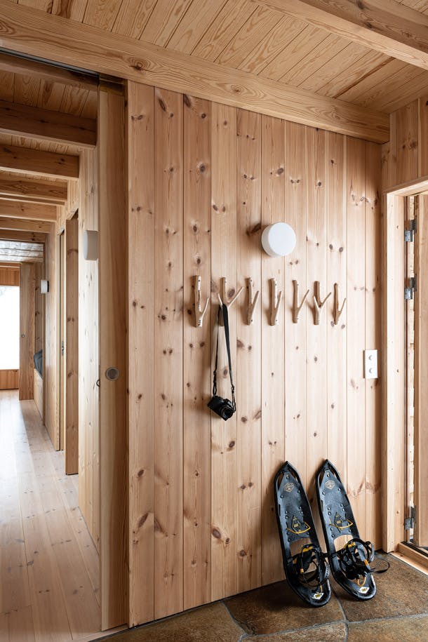 Je betreedt het huis via een simpele entree met een leistenen vloer. De hoofdruimte bevindt zich links. Rechts vind je de vleugel met de slaapkamers, die met een discrete schuifdeur kan worden afgesloten. Je betreedt het huis via een simpele entree met een leistenen vloer. De hoofdruimte bevindt zich links. Rechts vind je de vleugel met de slaapkamers, die met een discrete schuifdeur kan worden afgesloten.