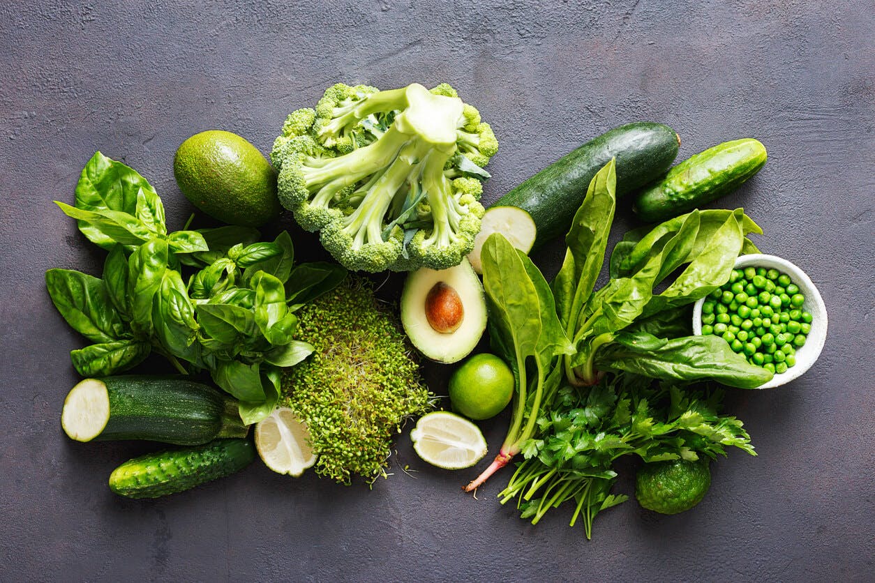 Vegetarian eller vegan? Ett urval av gröna grönsaker på ett bord.