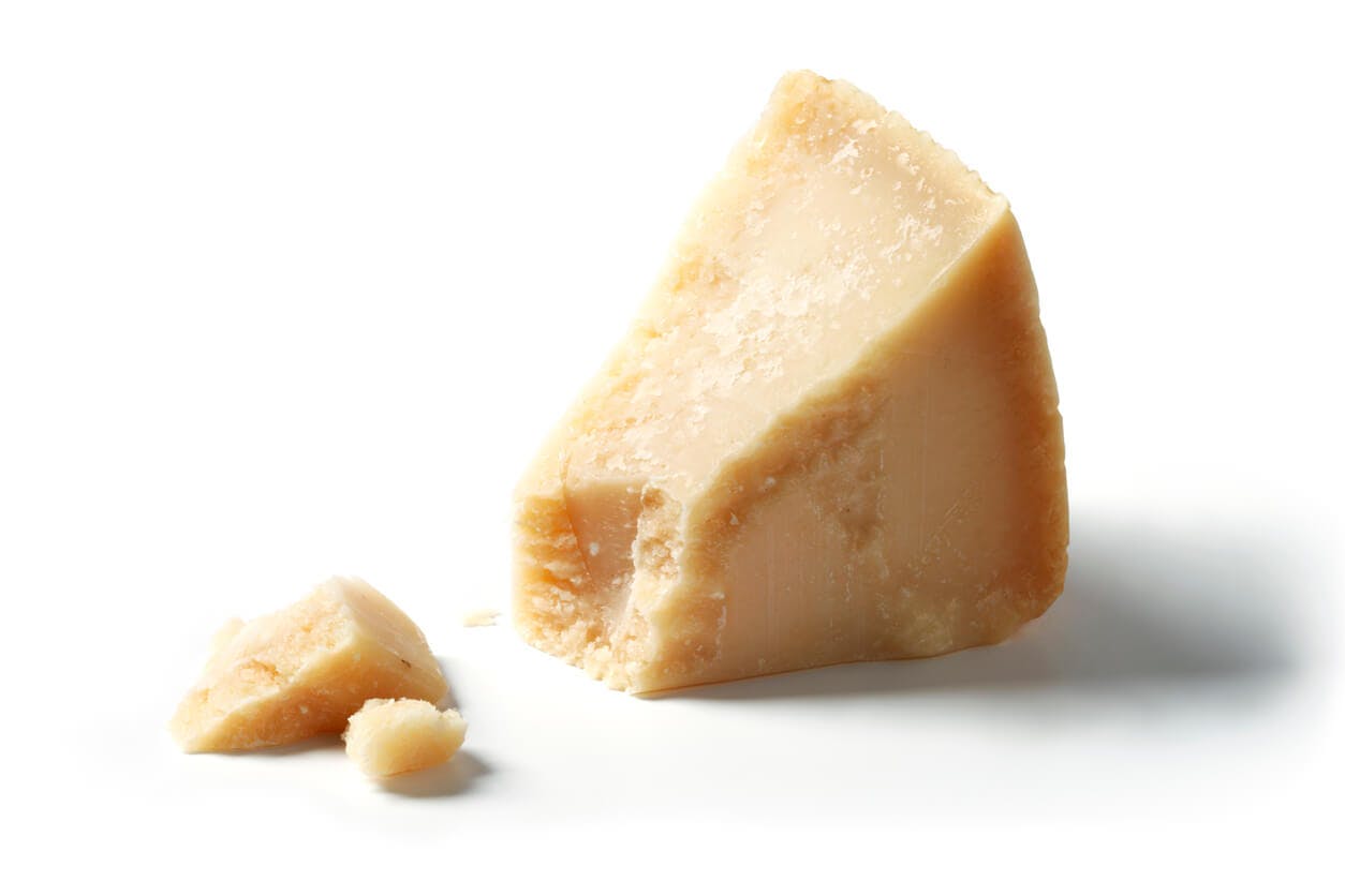 Parmesanost indeholder en god mængde protein. Parmesanost på hvid baggrund