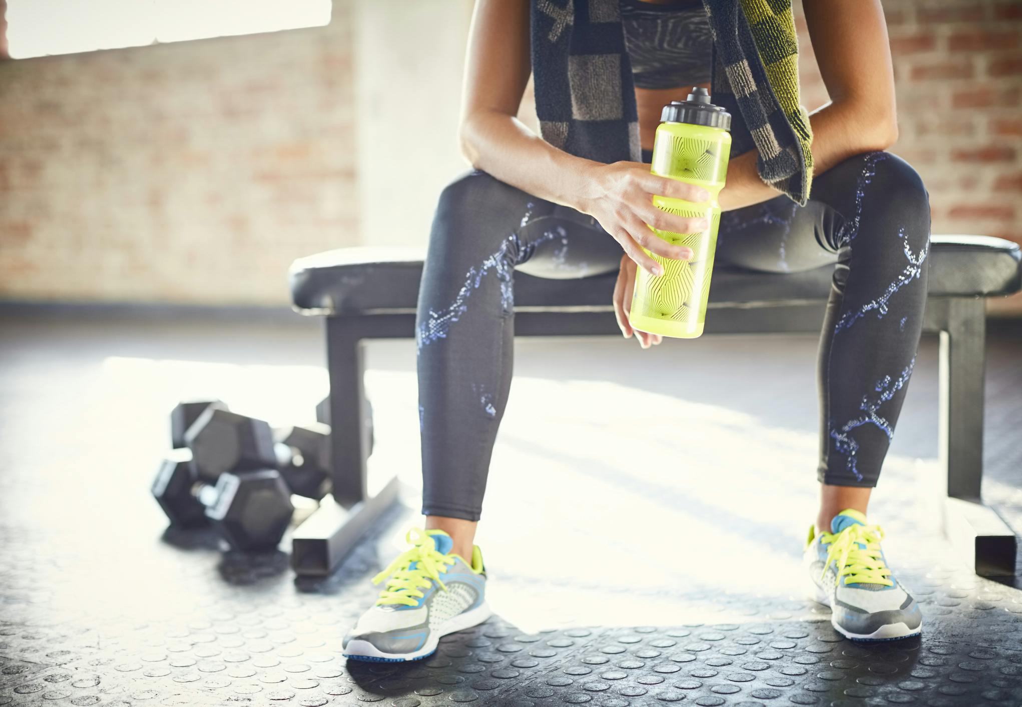 Kvinde i fitness med drikkedunk.