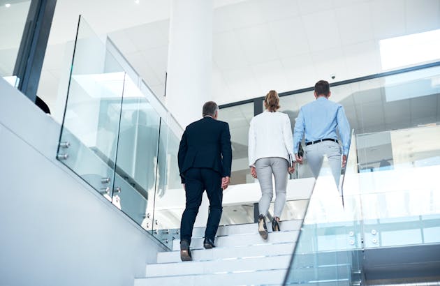 Two men and one woman take the stairs