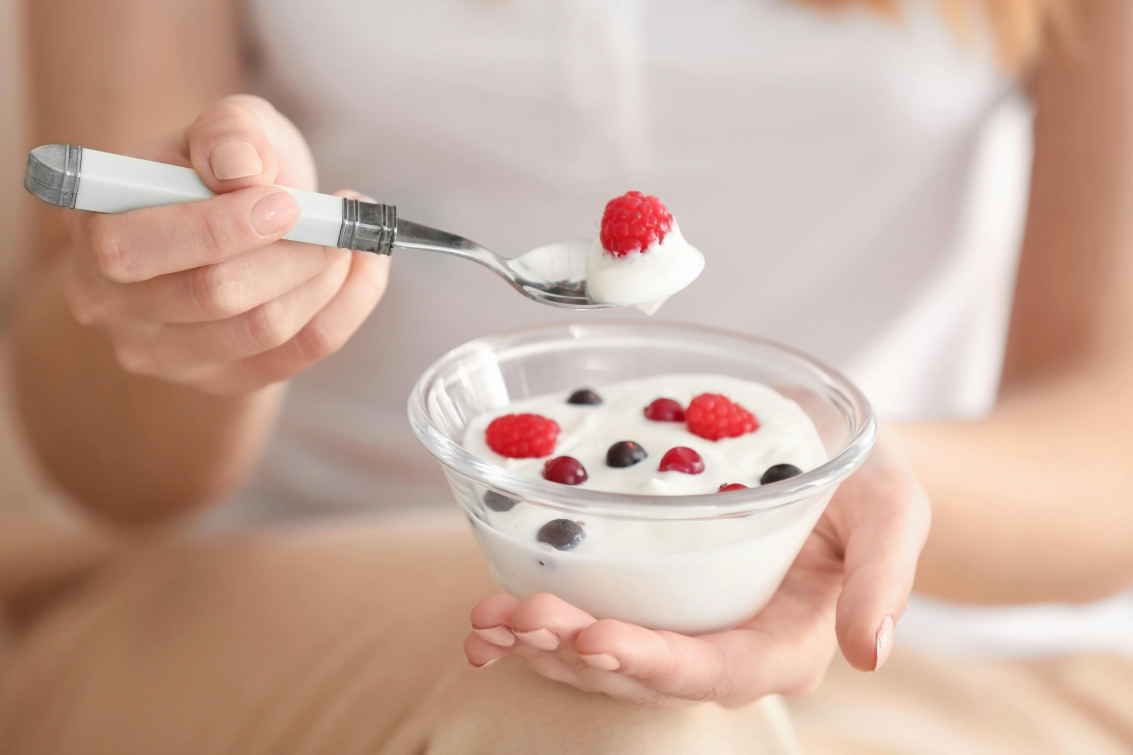 Kvinde holder en skål med Yogurt og friske bær