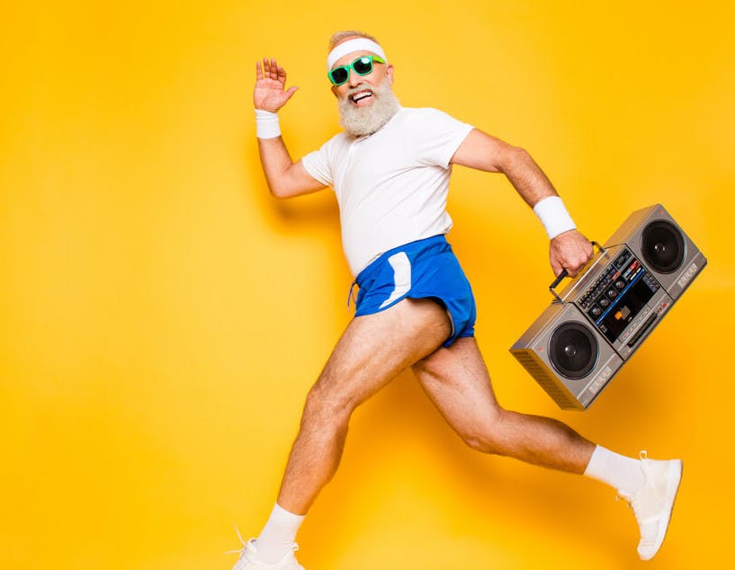 Bidt af en gal løber. glad seniorløber med ghettoblaster