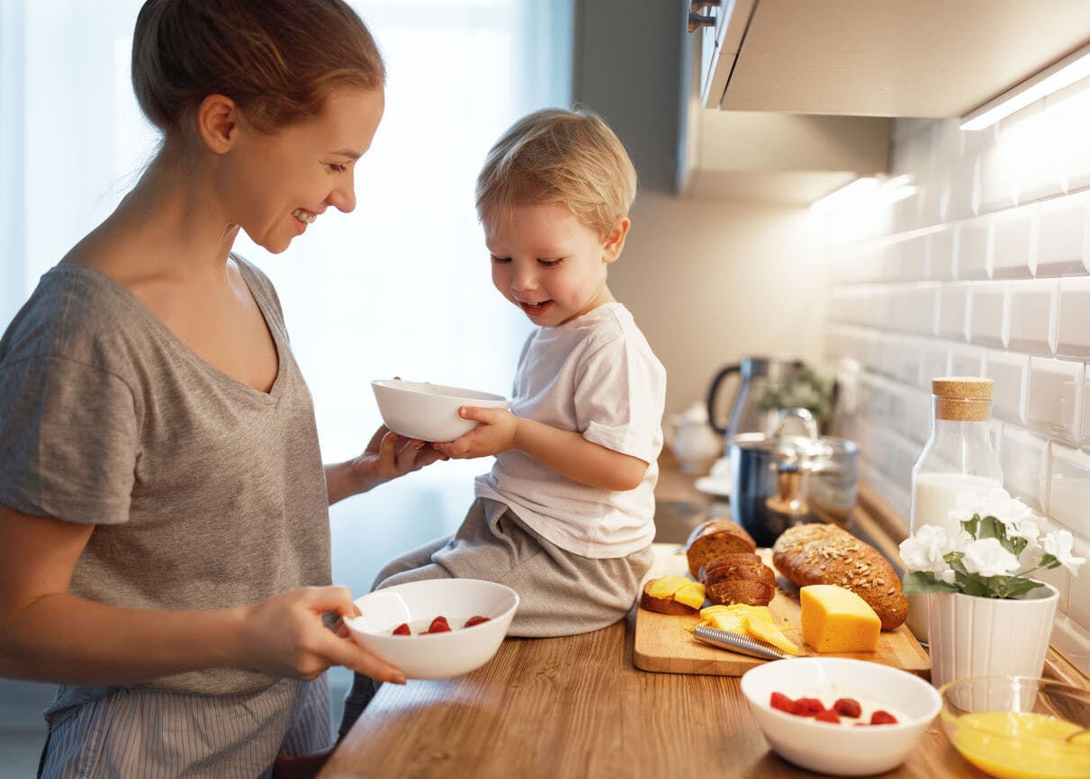 En bra start. Kvinna och barn lagar frukost tillsammans