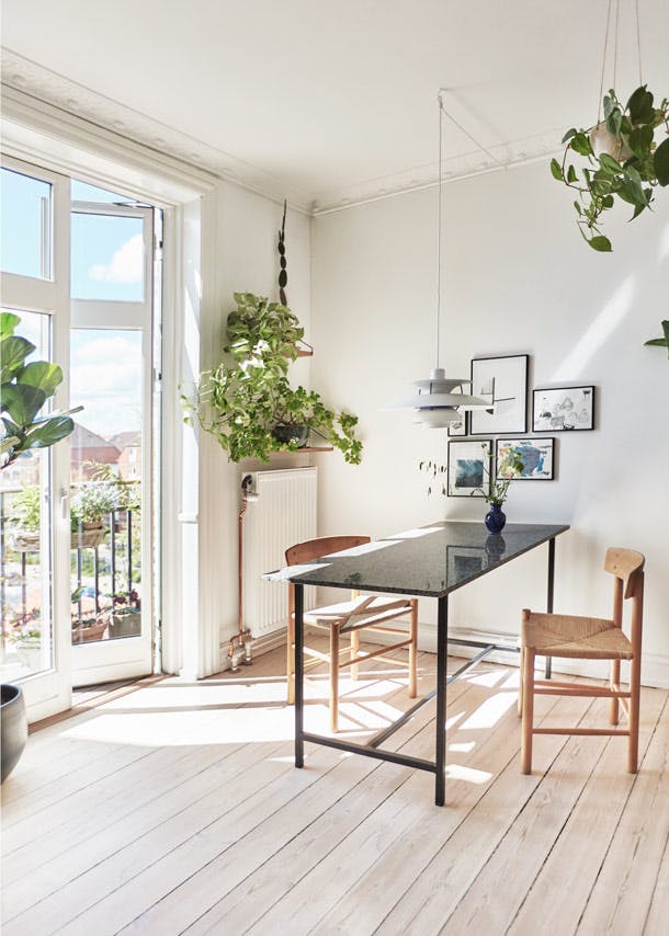 De smalle eettafel van graniet is van Nordal, eromheen staan klassieke J39-stoelen van Børge Mogensen. Boven tafel hangt een discrete PH-lamp. De smalle eettafel van graniet is van Nordal, eromheen staan klassieke J39-stoelen van Børge Mogensen. Boven tafel hangt een discrete PH-lamp.
